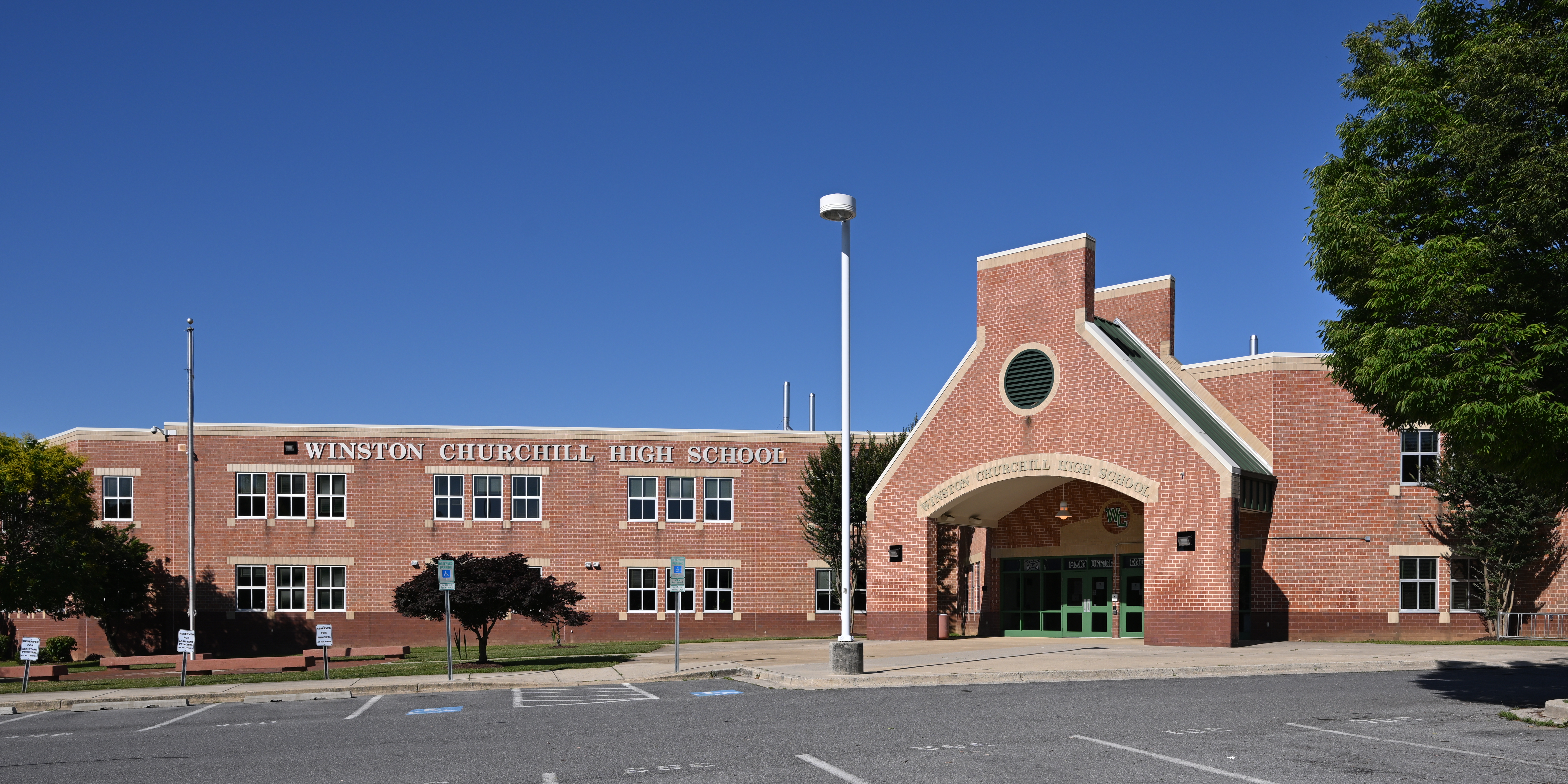 Red brick exterior of Winston Churchill High School with the school name visible on the facade.