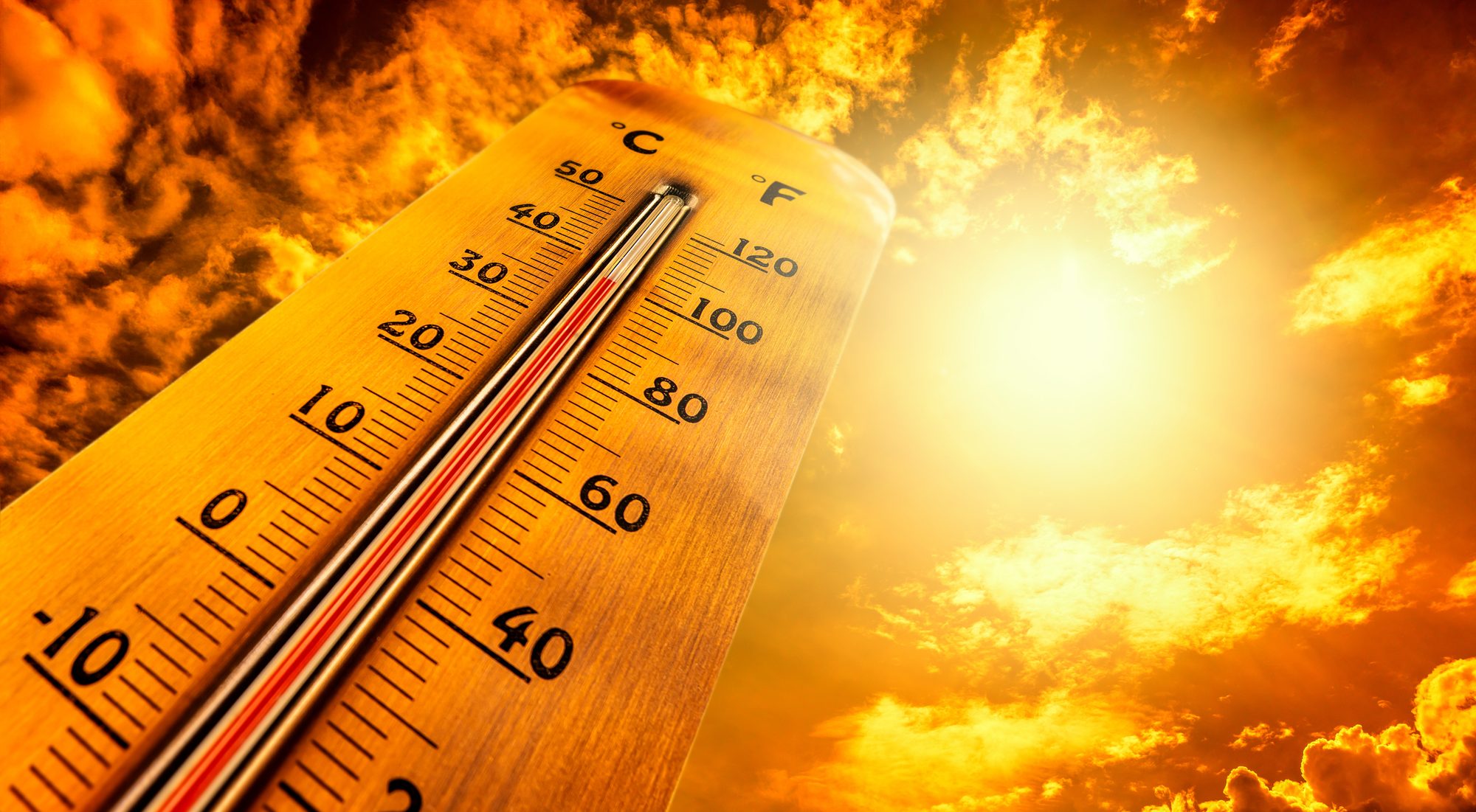 Thermometer showing tropical heat and sky with hot sun rays in Celsius and Fahrenheit