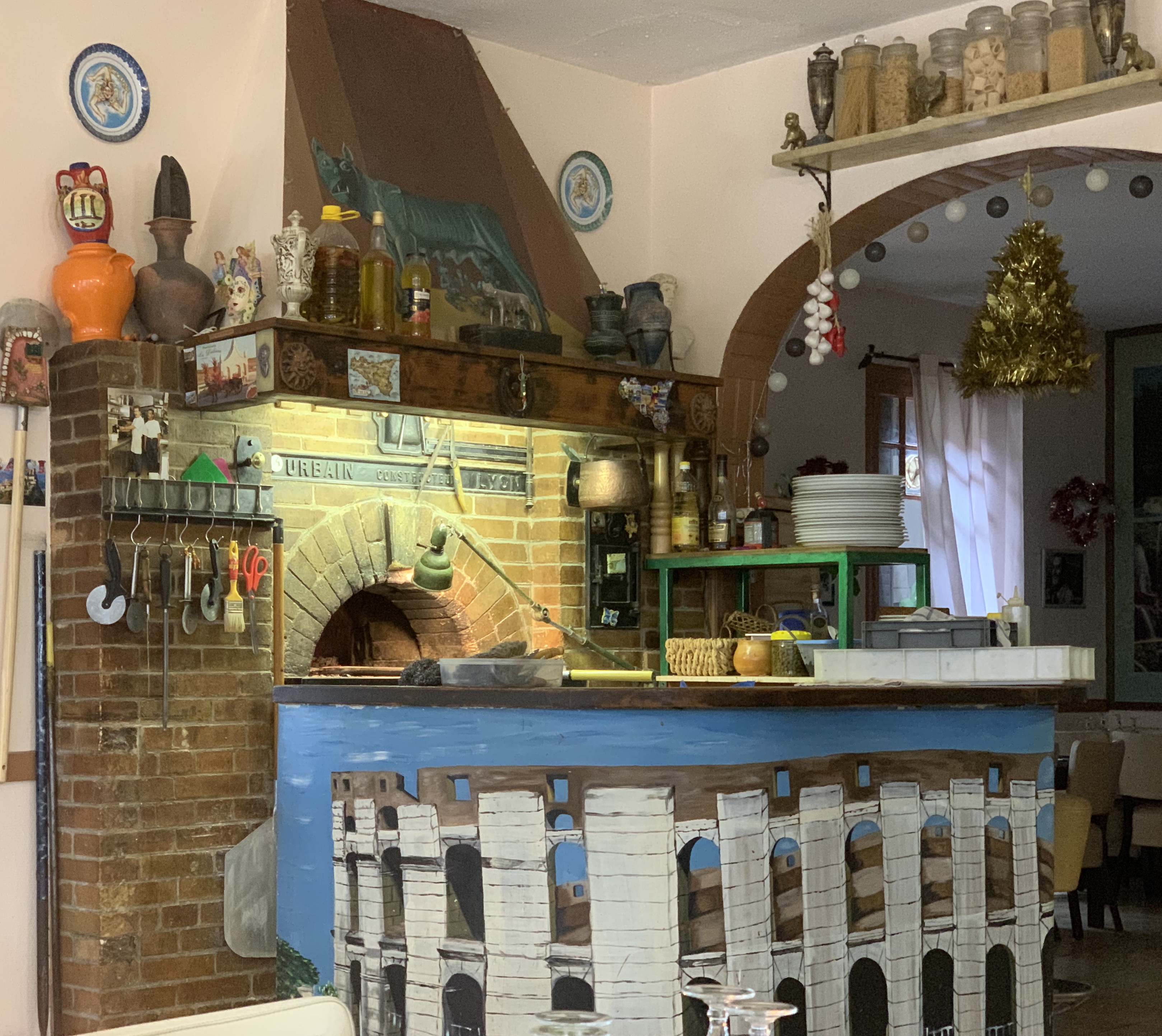 Brick wood-fired pizza oven inside a pizzeria interior.