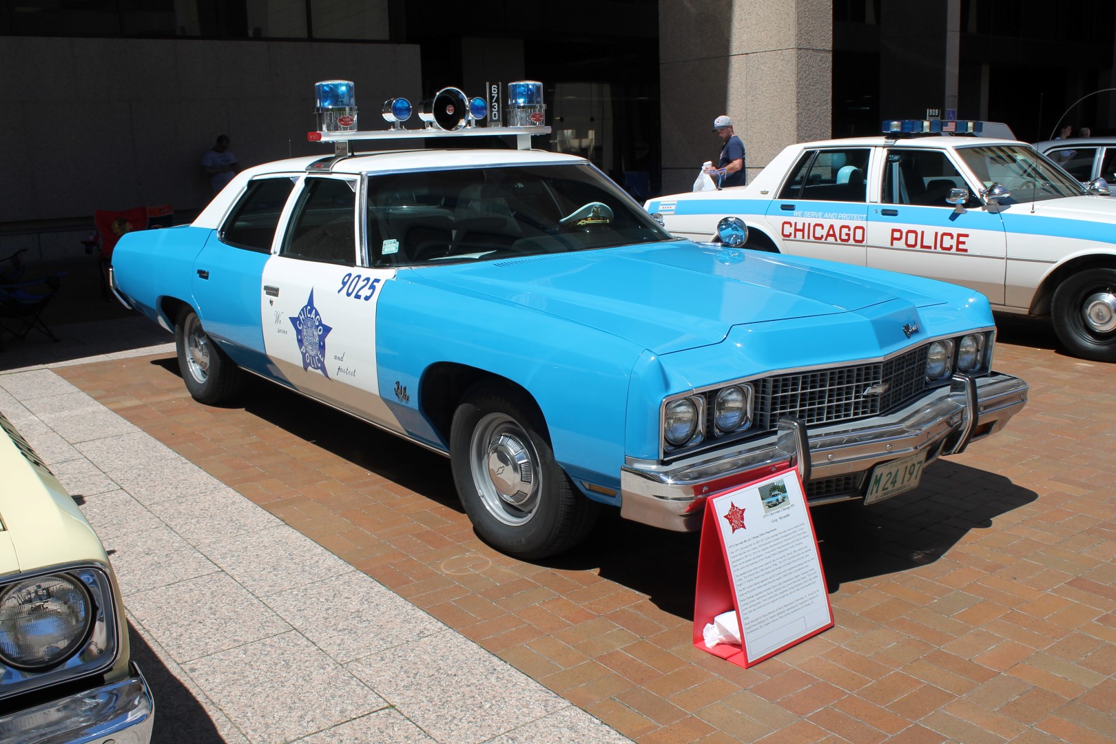 Vintage light-blue and white squad car displayed outdoors at a classic car show.