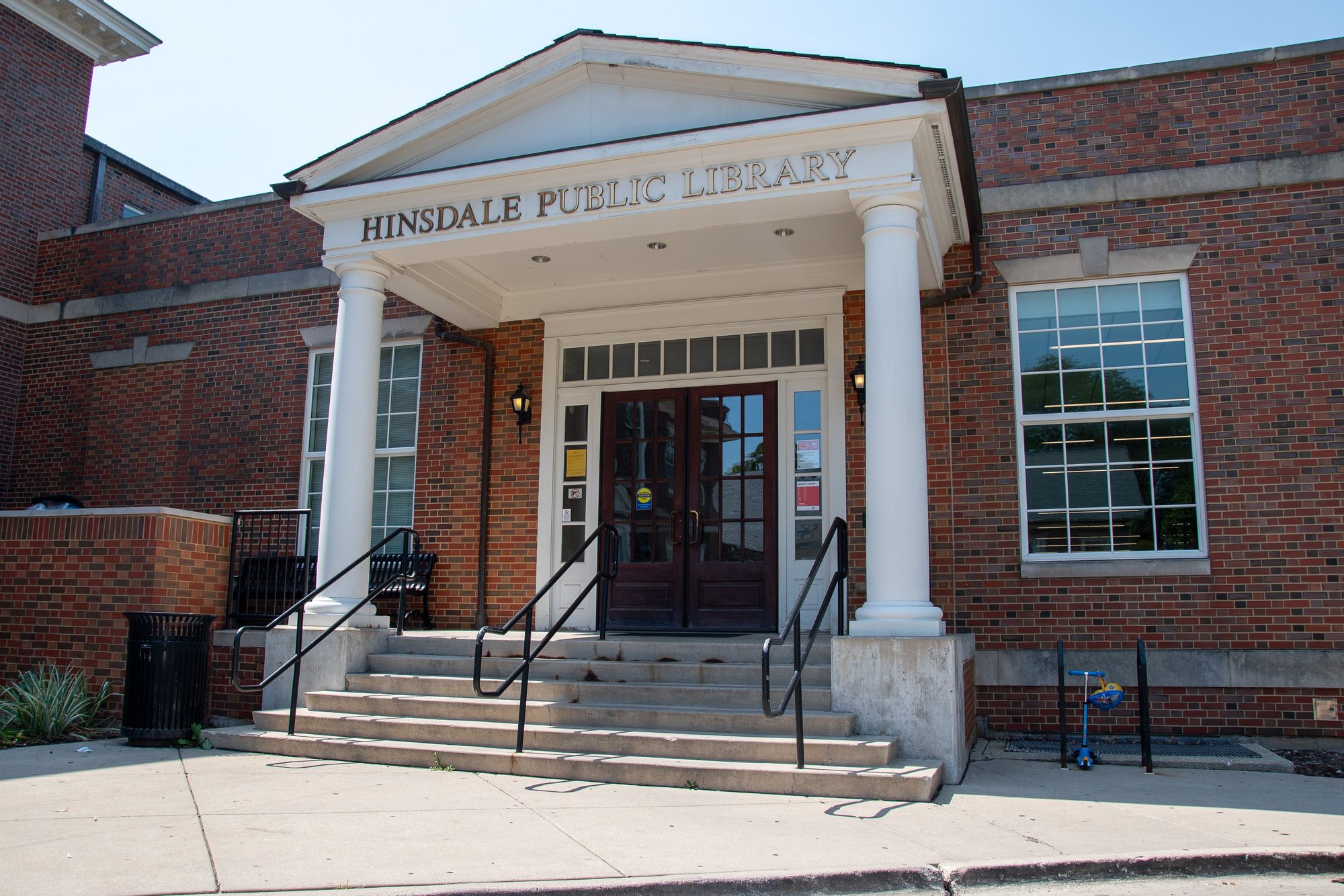 Brick public library building with white columns and glass entrance doors