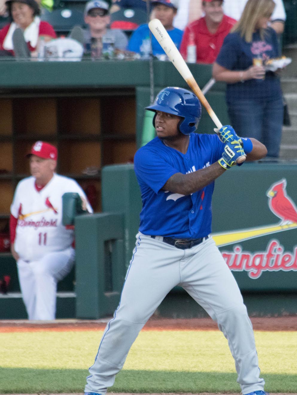 Baseball batter in a blue Tulsa Drillers uniform stands at home plate.