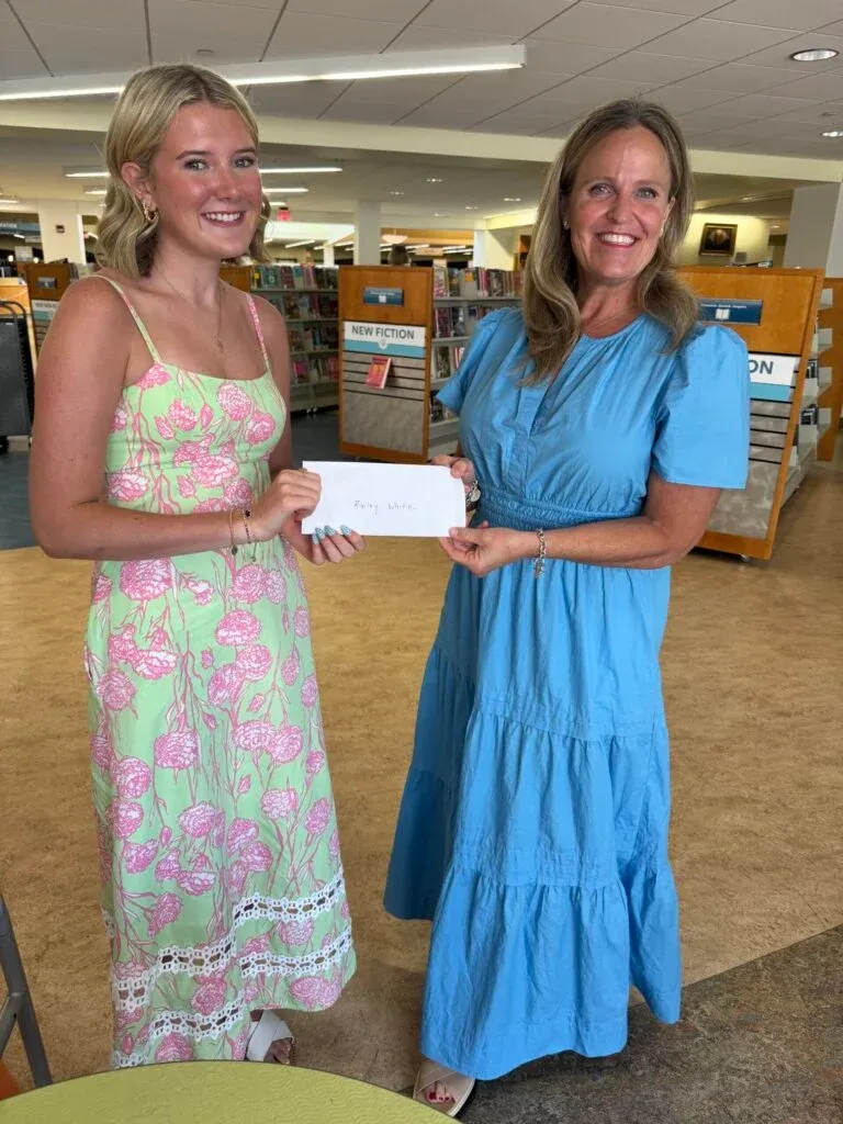 two women with a scholarship check