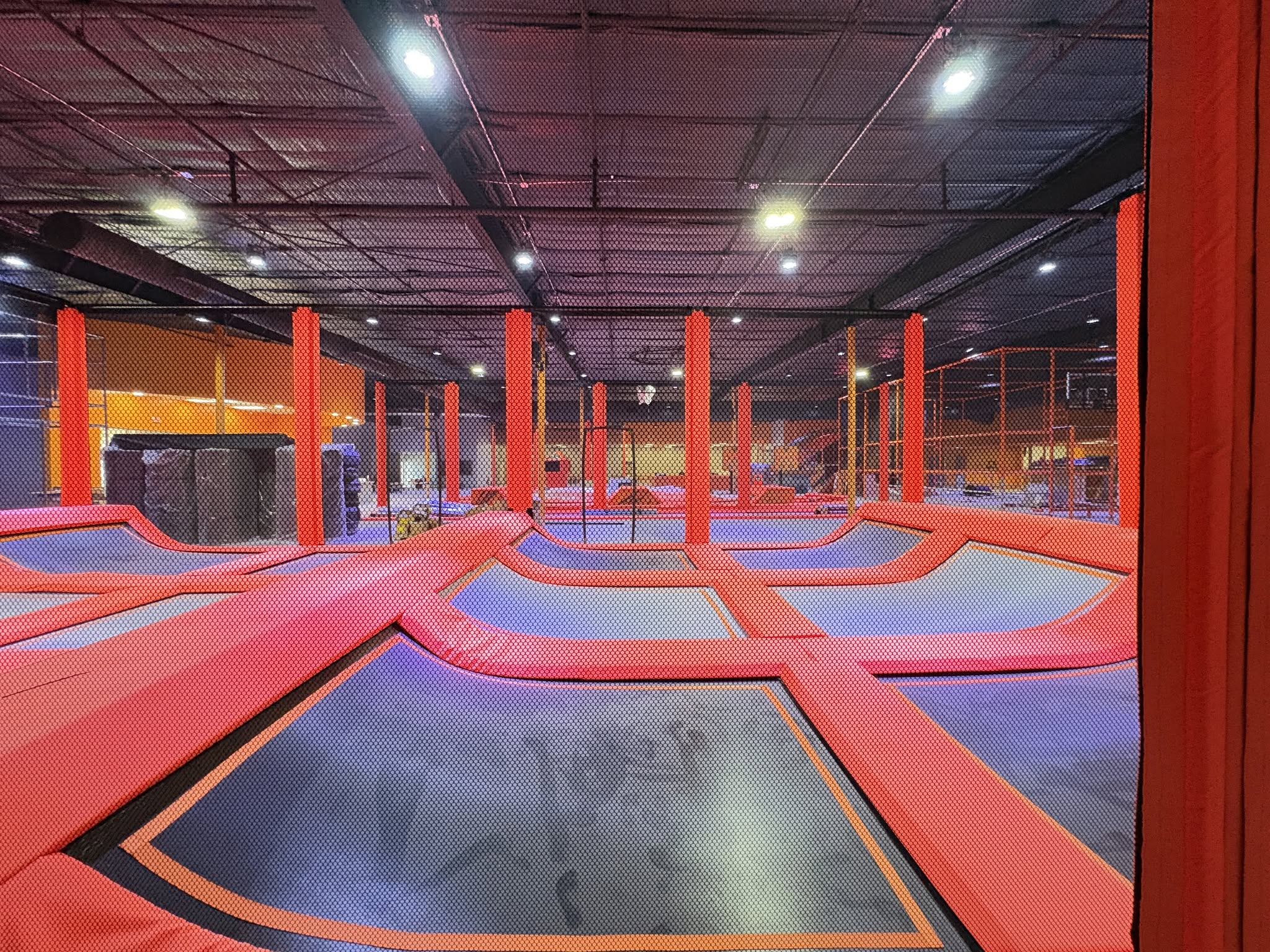 Trampoline park with orange dividers.