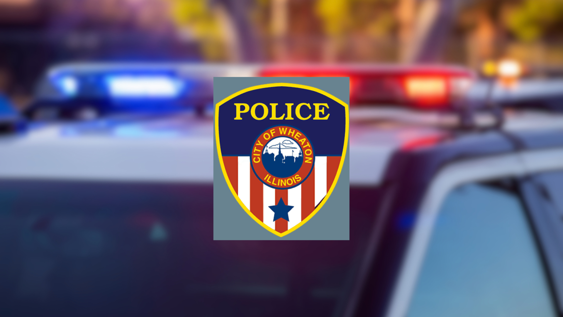 Logo of City of Wheaton Police Badge on blurred police cruiser background.