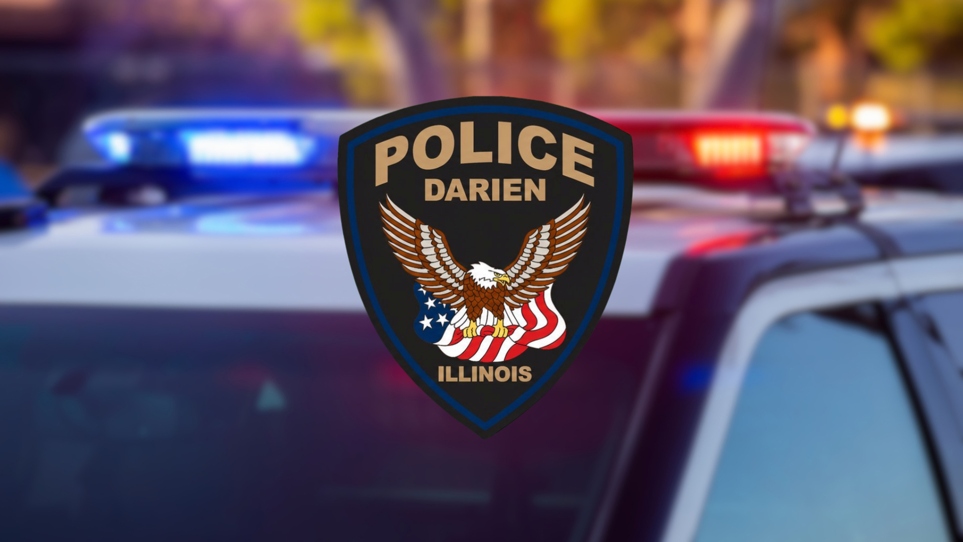 Police badge for Darien IL on blurred police car background.