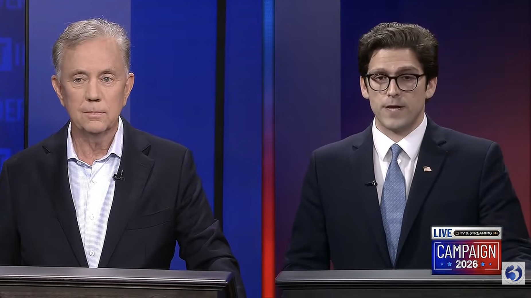 Two men stand behind lecterns in a television studio during a broadcast labeled “Campaign 2026.”
