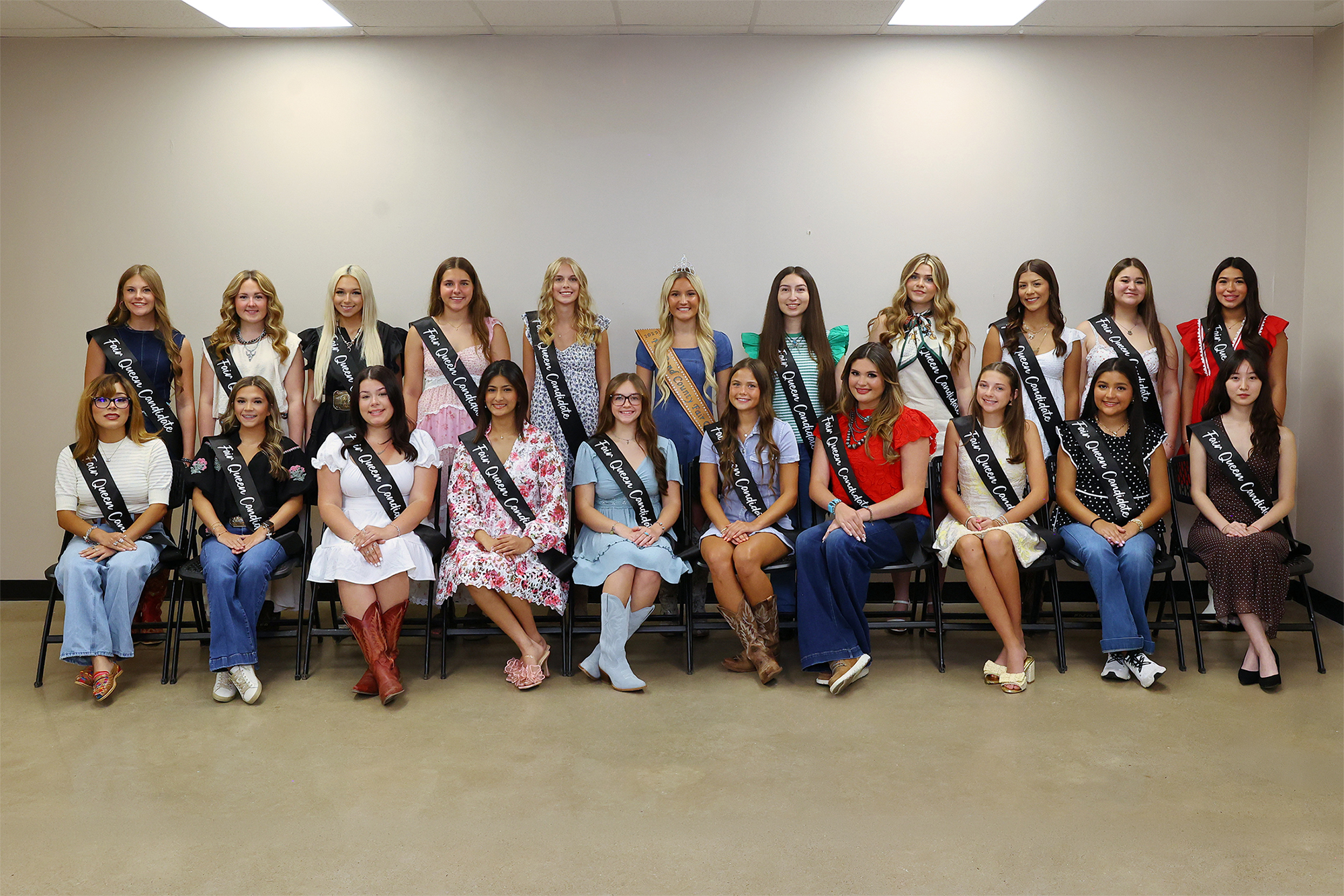 Group photo of 20 Fort Bend County Fair and Rodeo queen candidates wearing sashes and posing in two rows.