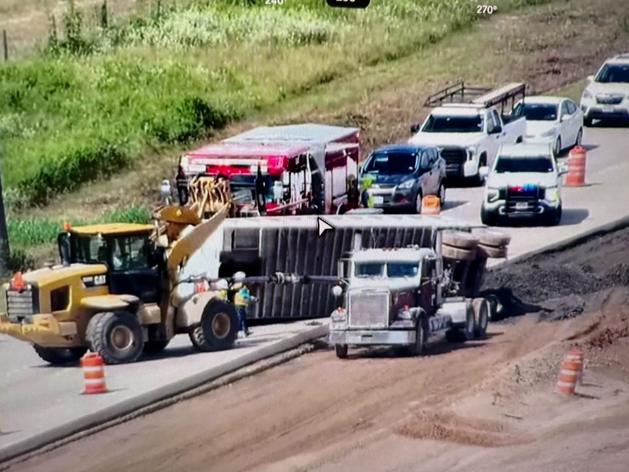 Truck rolled over on side of the road causing traffic backup.