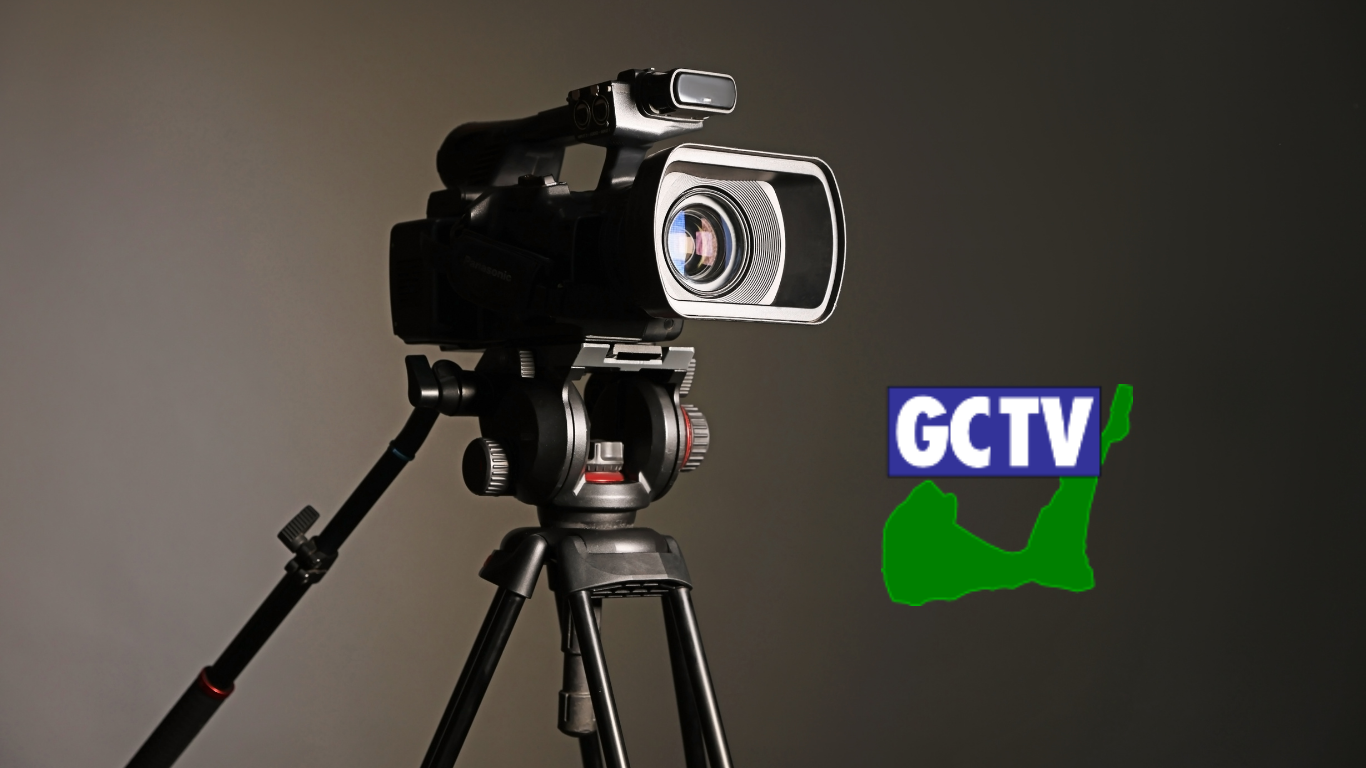 Black video camera on stand with logo for Greenwich Community Television.