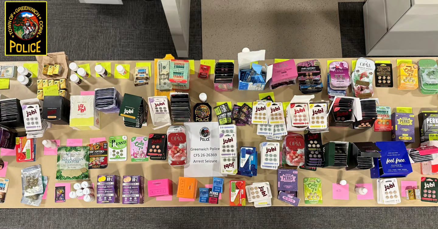 Police display of seized THC products, vapes, cash, and other items arranged on a table during a Greenwich, Connecticut arrest investigation.