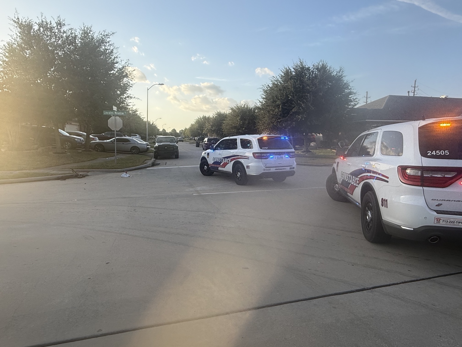 Police vehicles on scene with emergency lights on in the middle of a street.