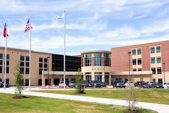 Texas and USA Flag in front of a high school building