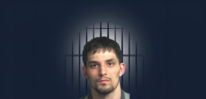 Man in front of jail bars standing for mug shot picture.