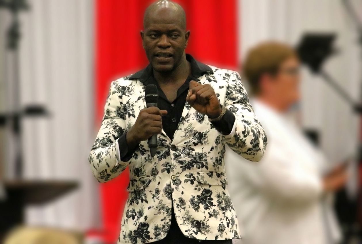 Moliere “Moe” Dimanche speaks into a microphone in Polk County, Florida.