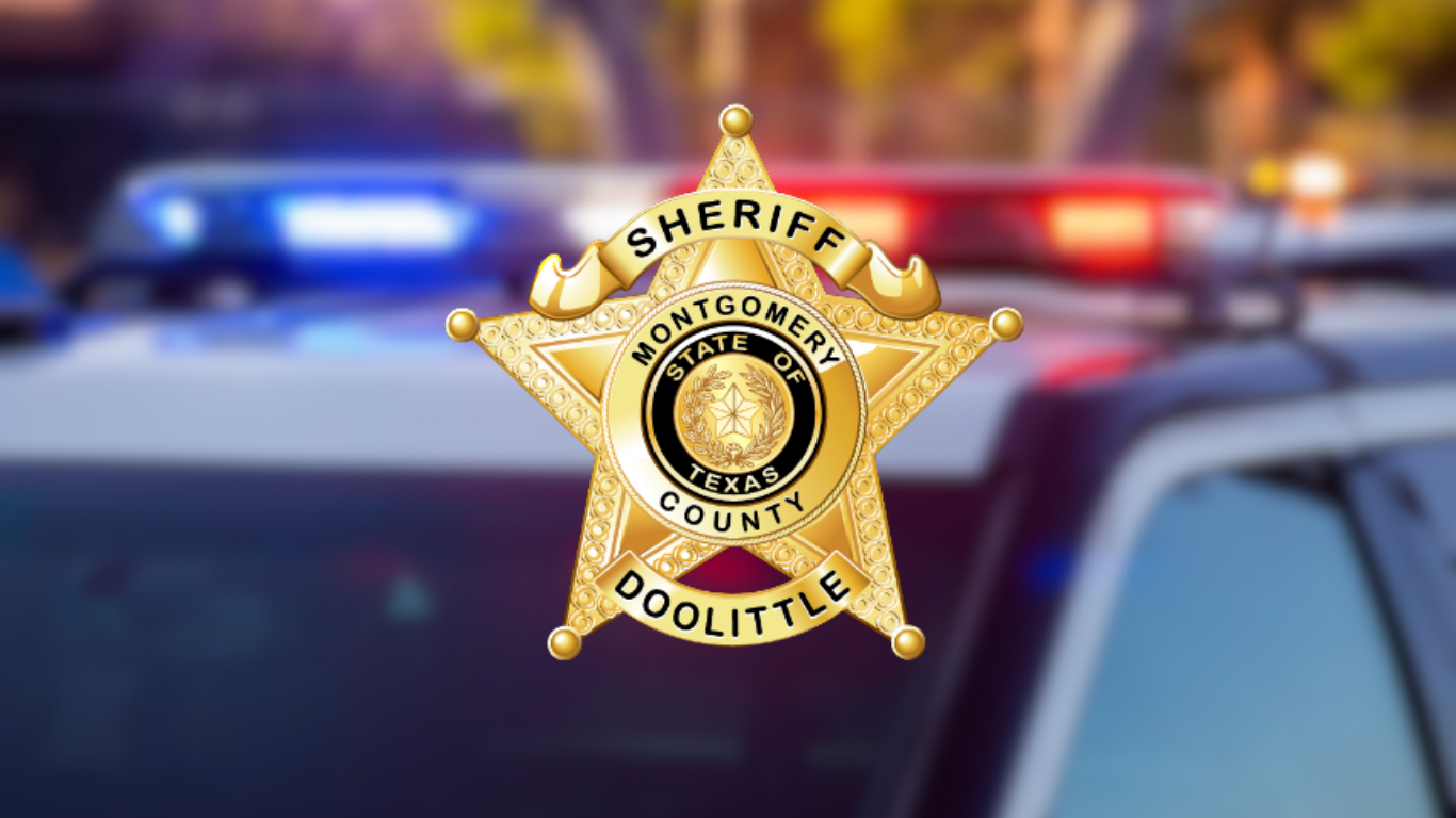 Gold five-pointed star badge reading "Sheriff, Montgomery County, Doolittle, State of Texas," displayed over a blurred background of a police vehicle with activated emergency lights.
