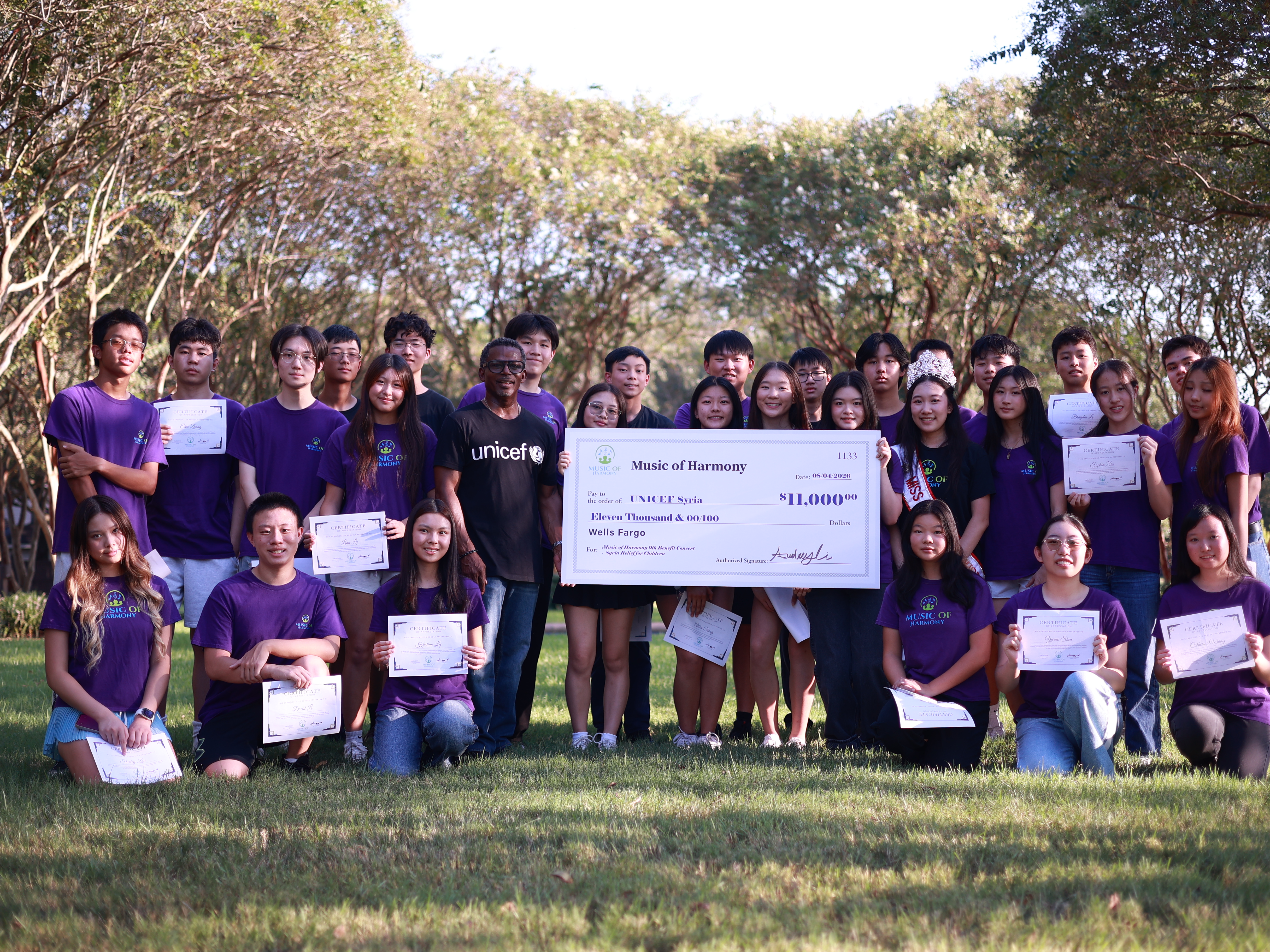 Group stands with check for donation.