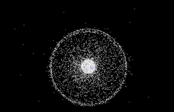 A computer-generated NASA visualization showing thousands of tracked debris objects in orbit around Earth, clustered densely in low Earth orbit.