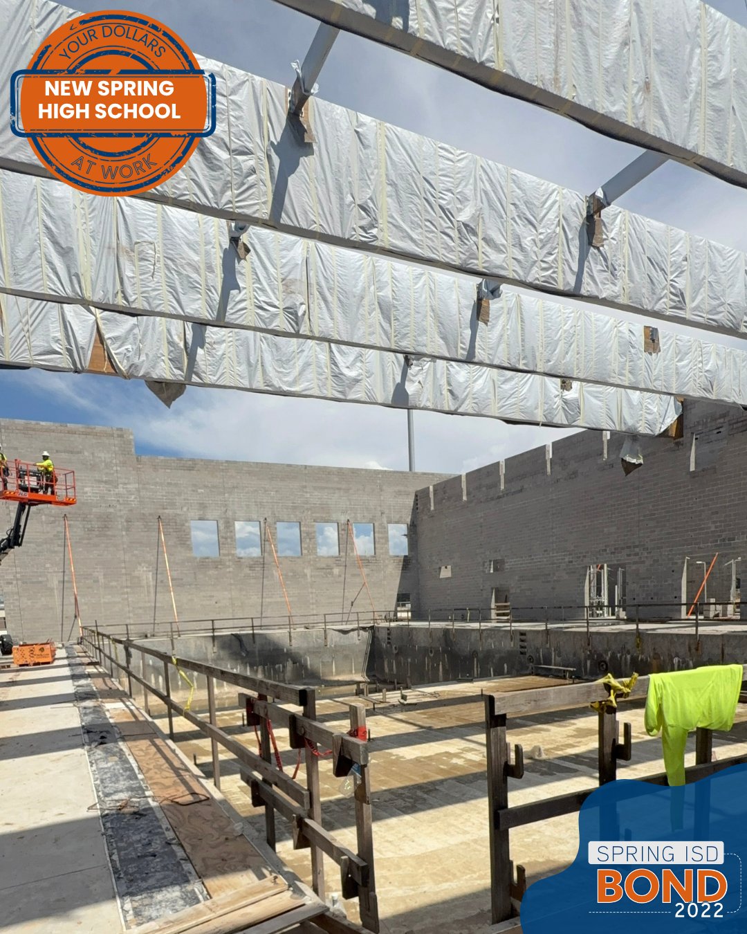 Construction site wit hbeams and concrete walls for new high school pool.