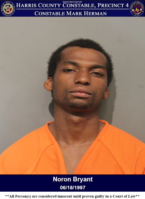 Man standing for mugshot photo in orange jump suit.