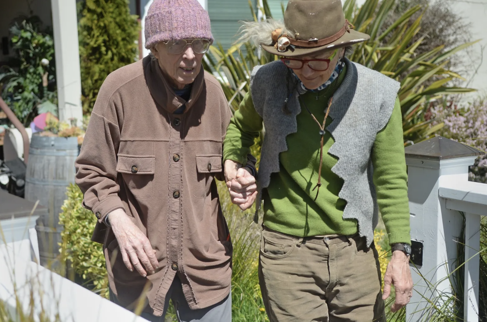 Charlie Cunningham and his wife, Jacquie Phelan, walk hand-in-hand outside a home in San Anselmo.