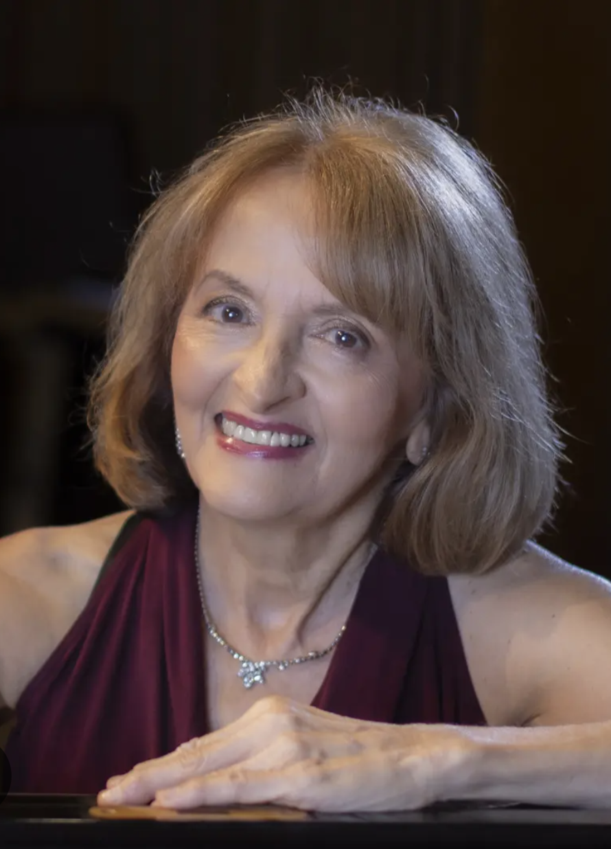 Pianist Louise Costigan-Kerns at a grand piano.