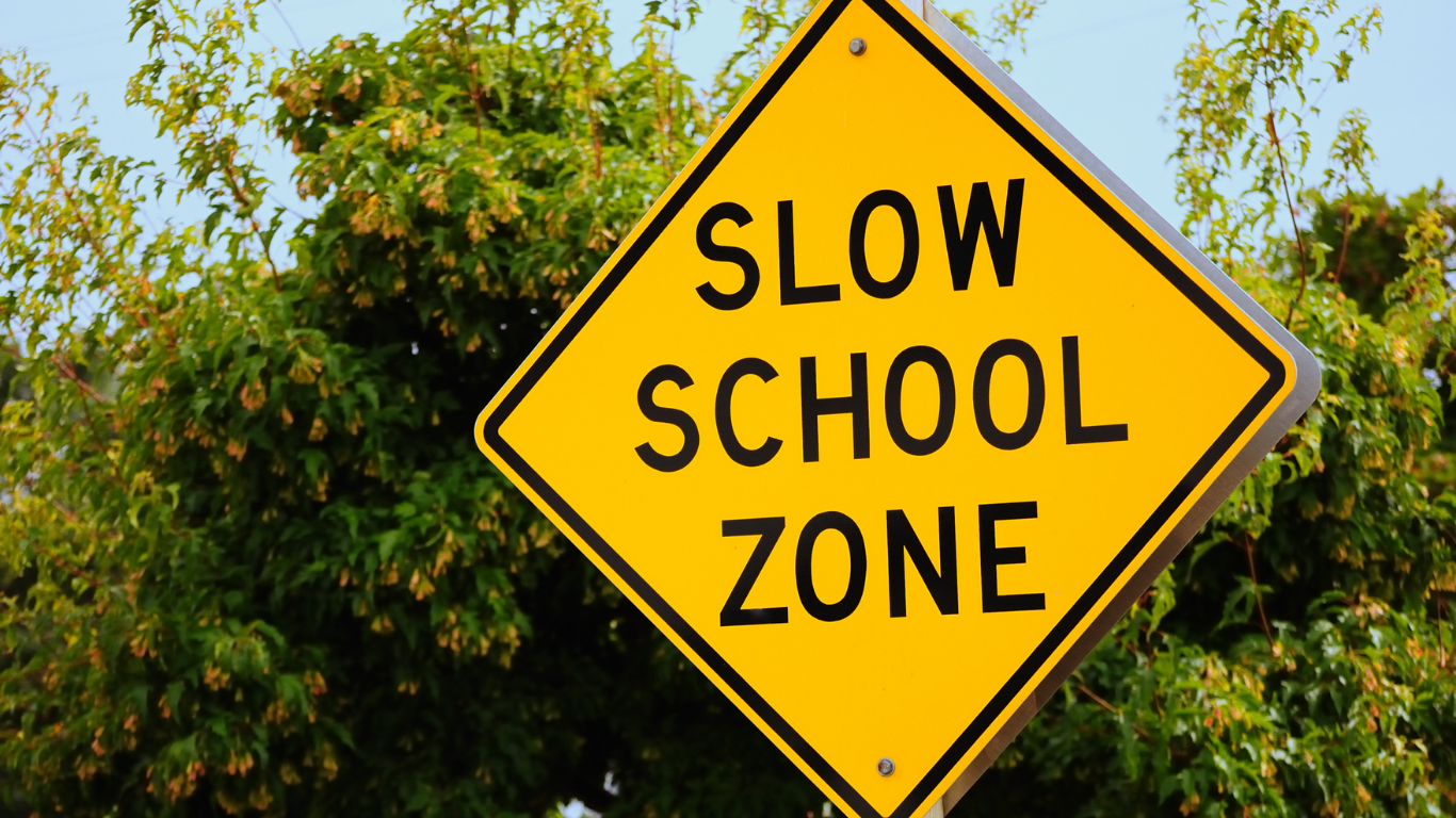 Yellow sign warning drivers to slow down for school zone
