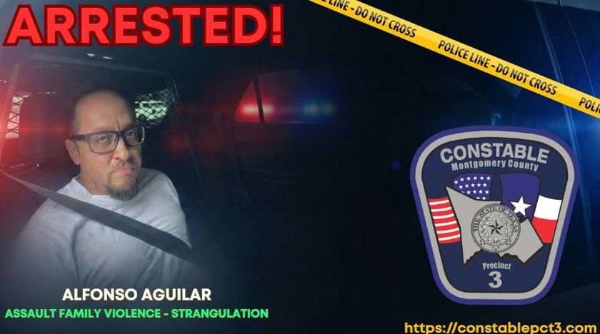 Man sitting in the back of a cop cruiser buckled in.