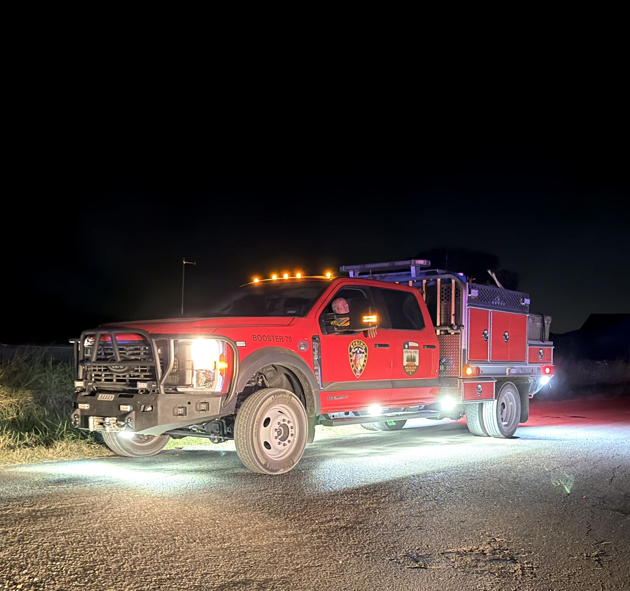 Red public safety vehicle with lights on at night.