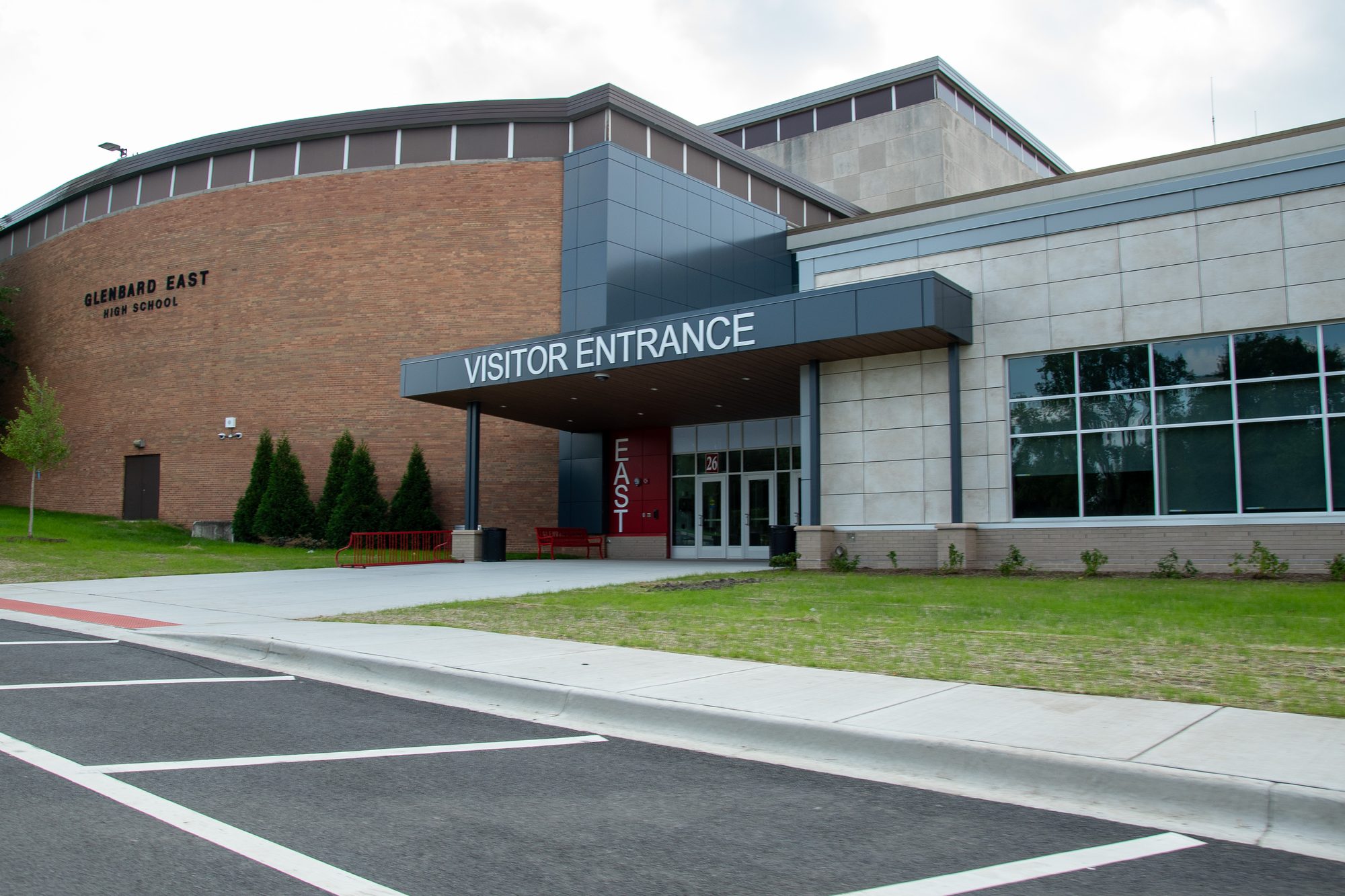 Exterior visitor entrance of Glenbard East High School with brick and modern facade.