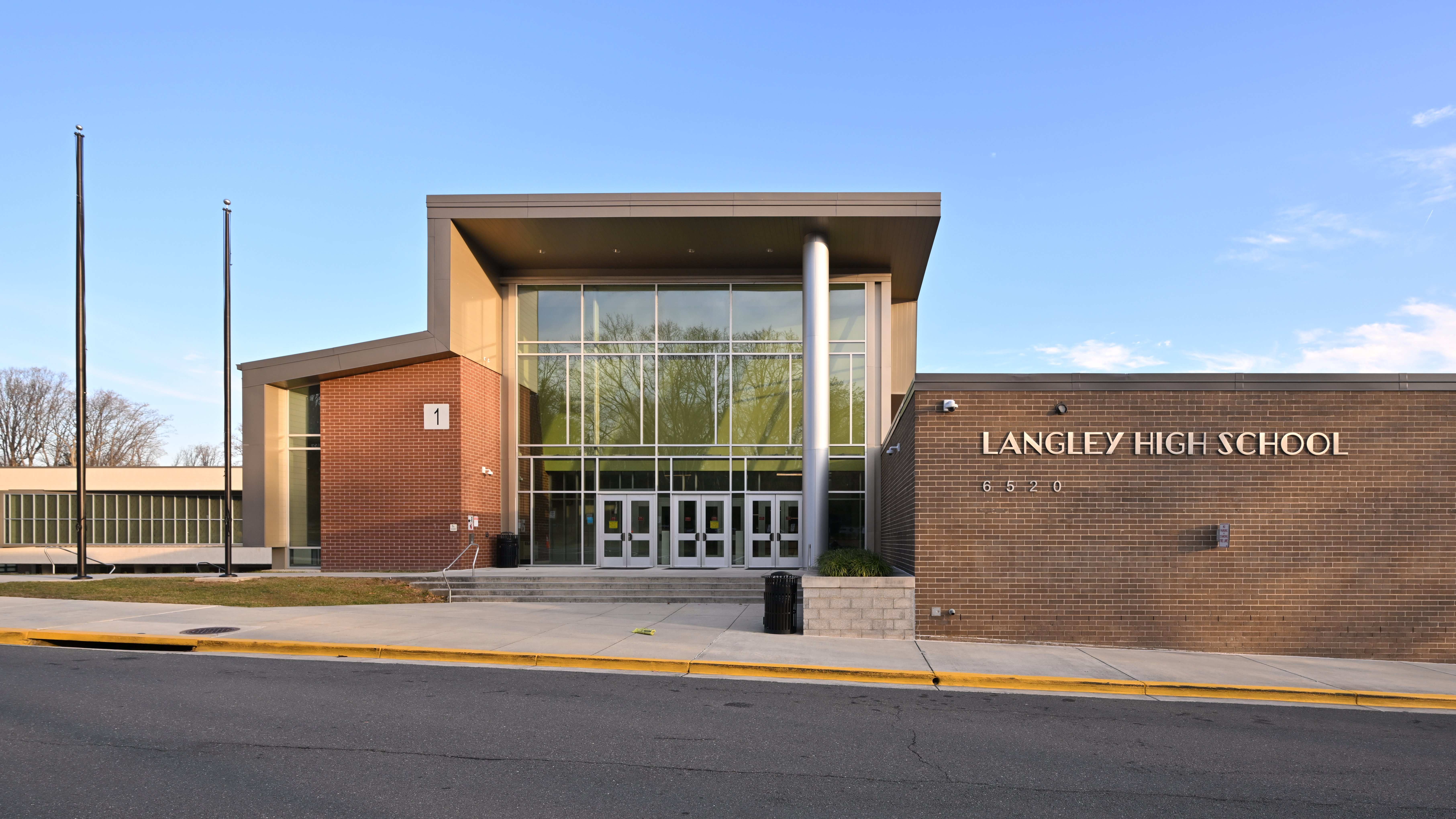 Main entrance of Langley High School, a brick building with large glass windows.