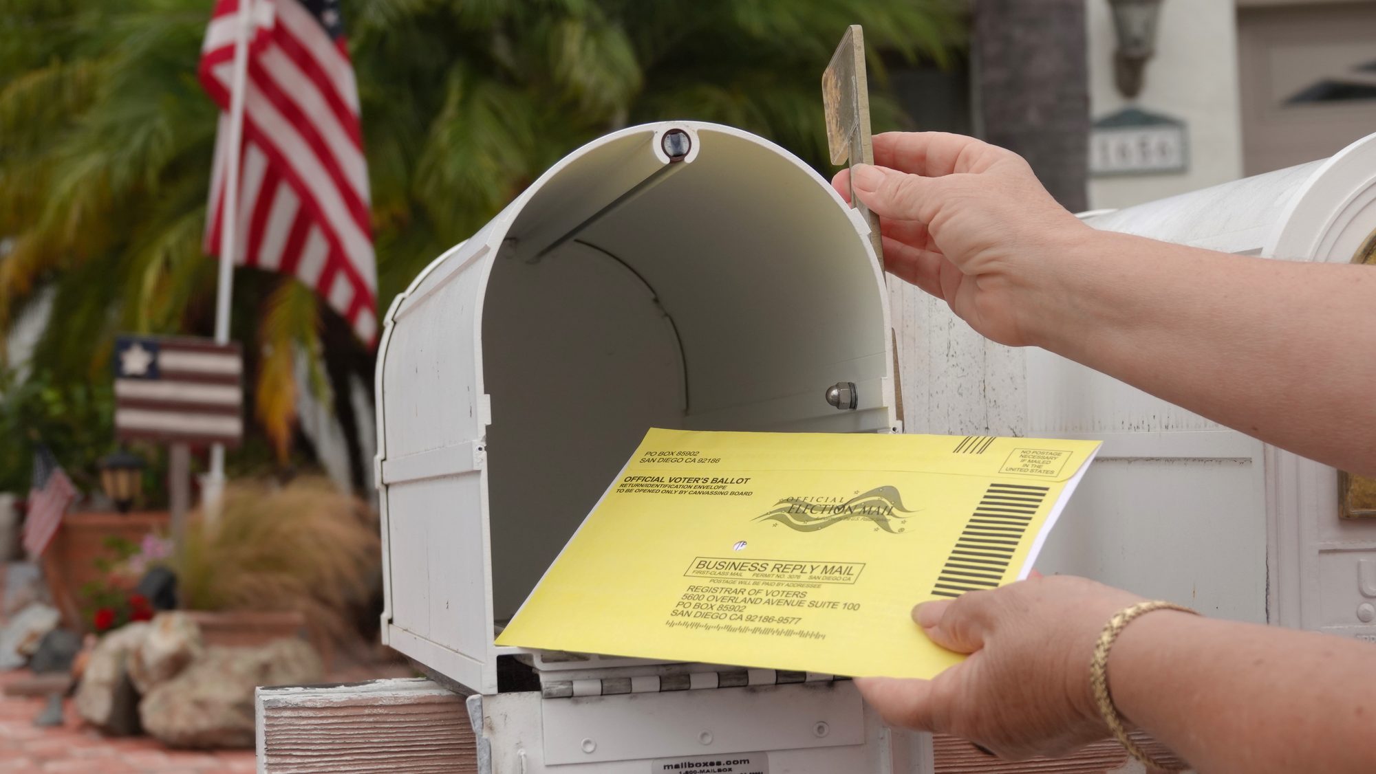 Woman puts US mail-in ballot into mailbox