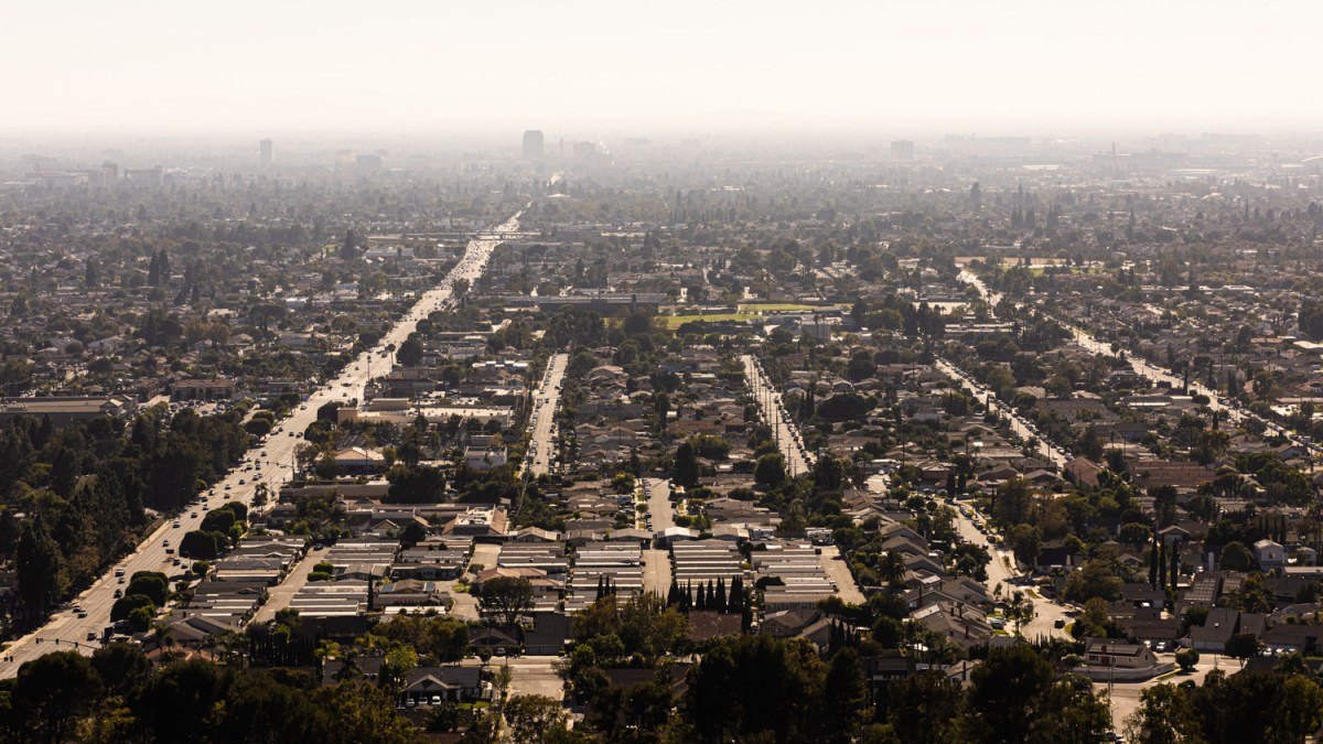 Aerial view of sprawling residential neighborhoods stretching to the horizon under hazy skies.