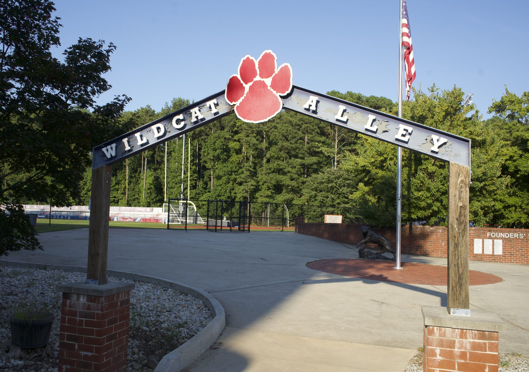Entrance arch reading Wildcat Alley with a red paw print logo and American flag.