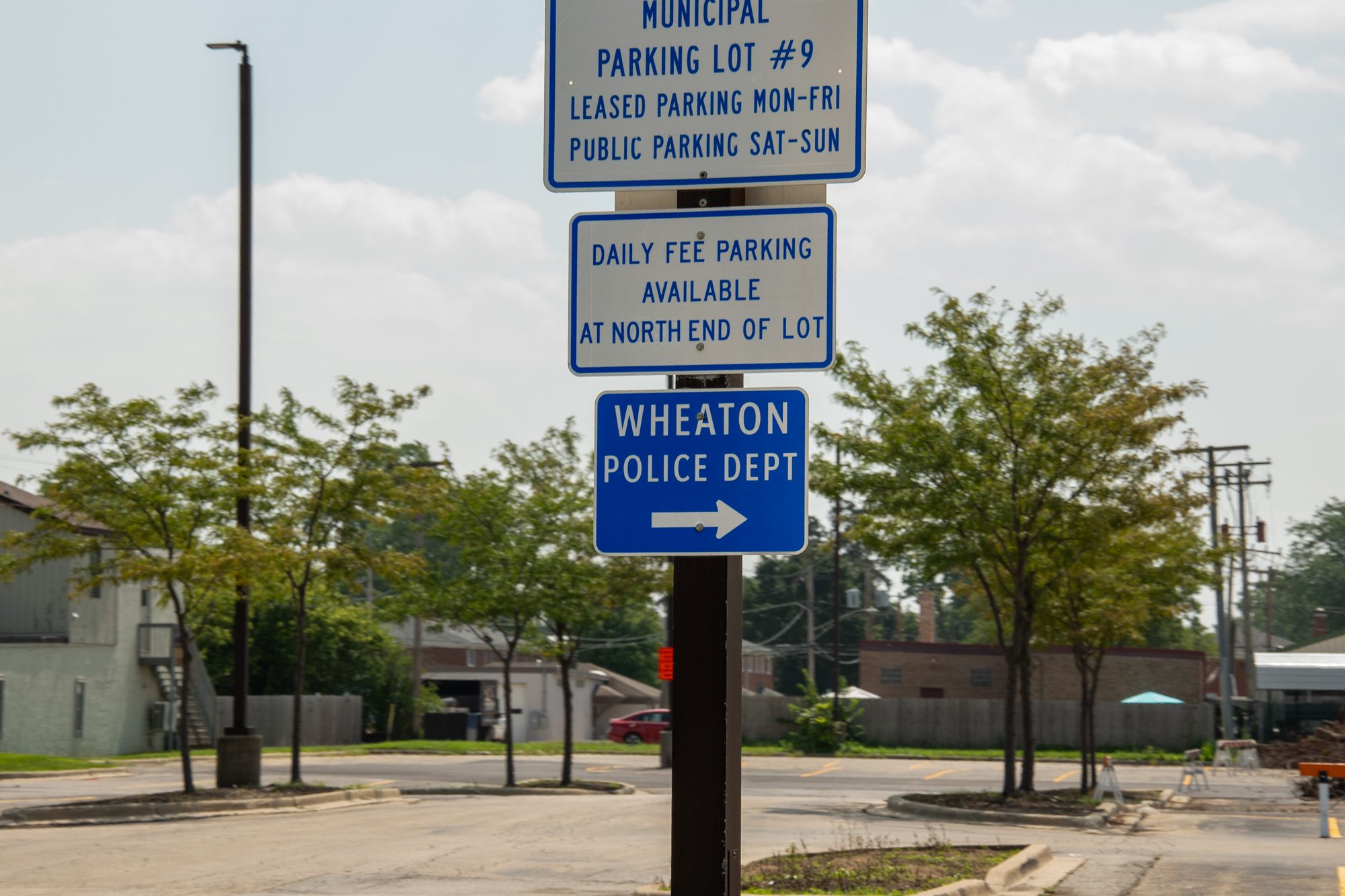 Directional signs for municipal parking and the Wheaton Police Department.