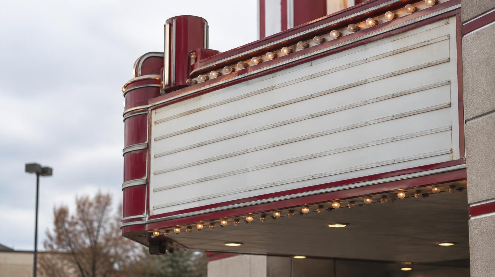 Blank marquee sign on the exterior of a suburban movie theater building.