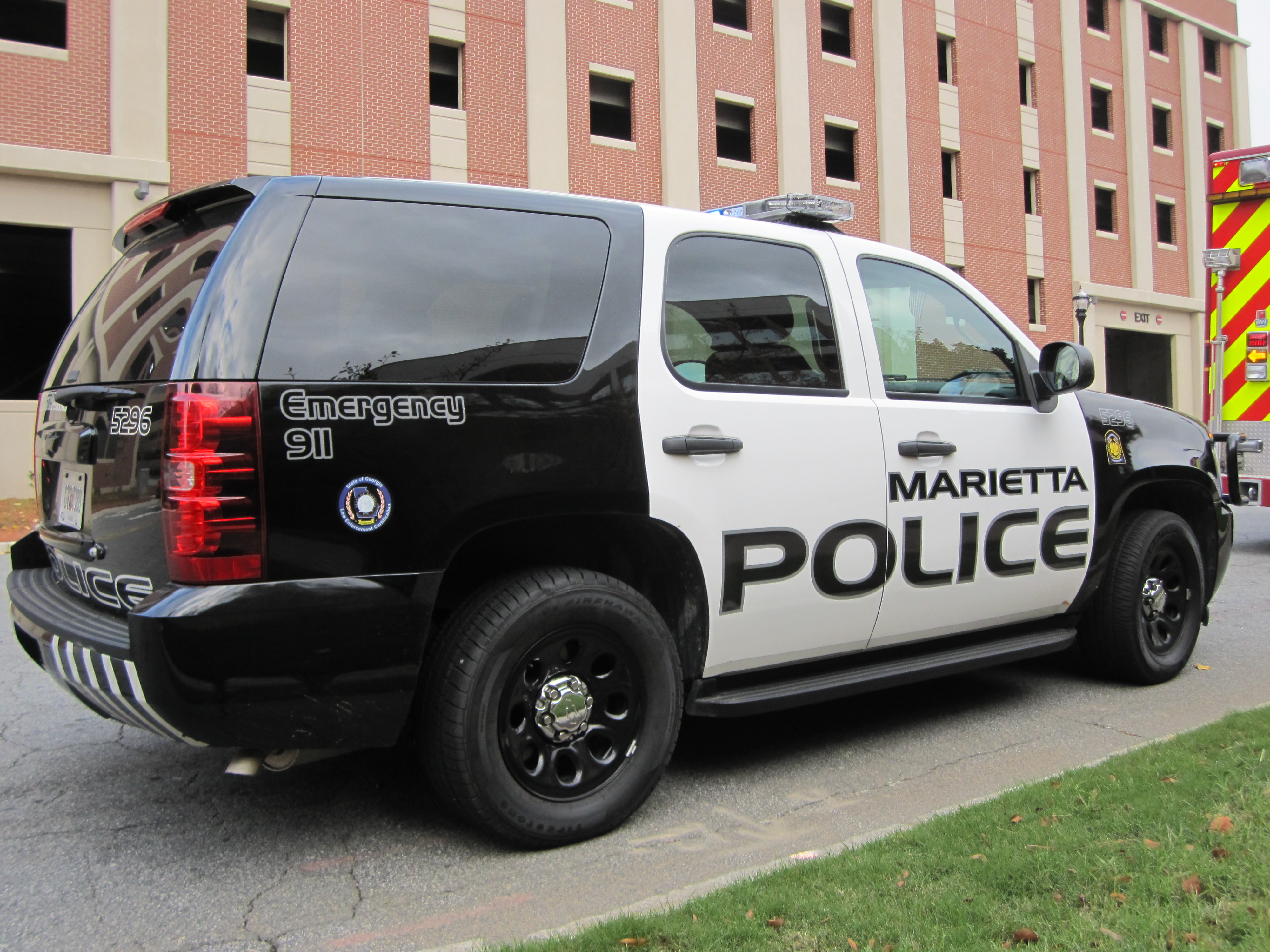 A black-and-white Marietta Police SUV parked in front of a brick building.