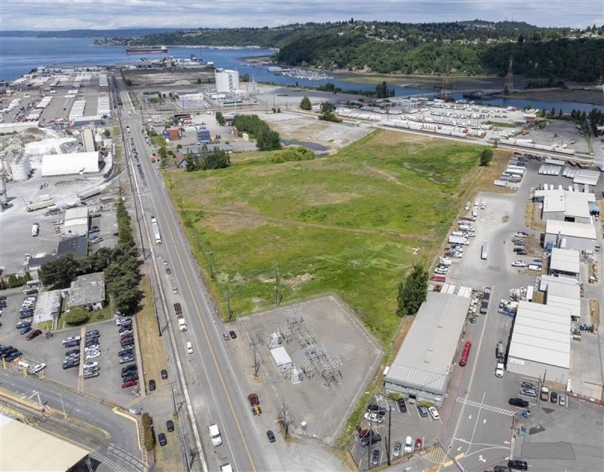 Aerial view of a large undeveloped industrial parcel bordered by roads, rail lines, and port facilities.