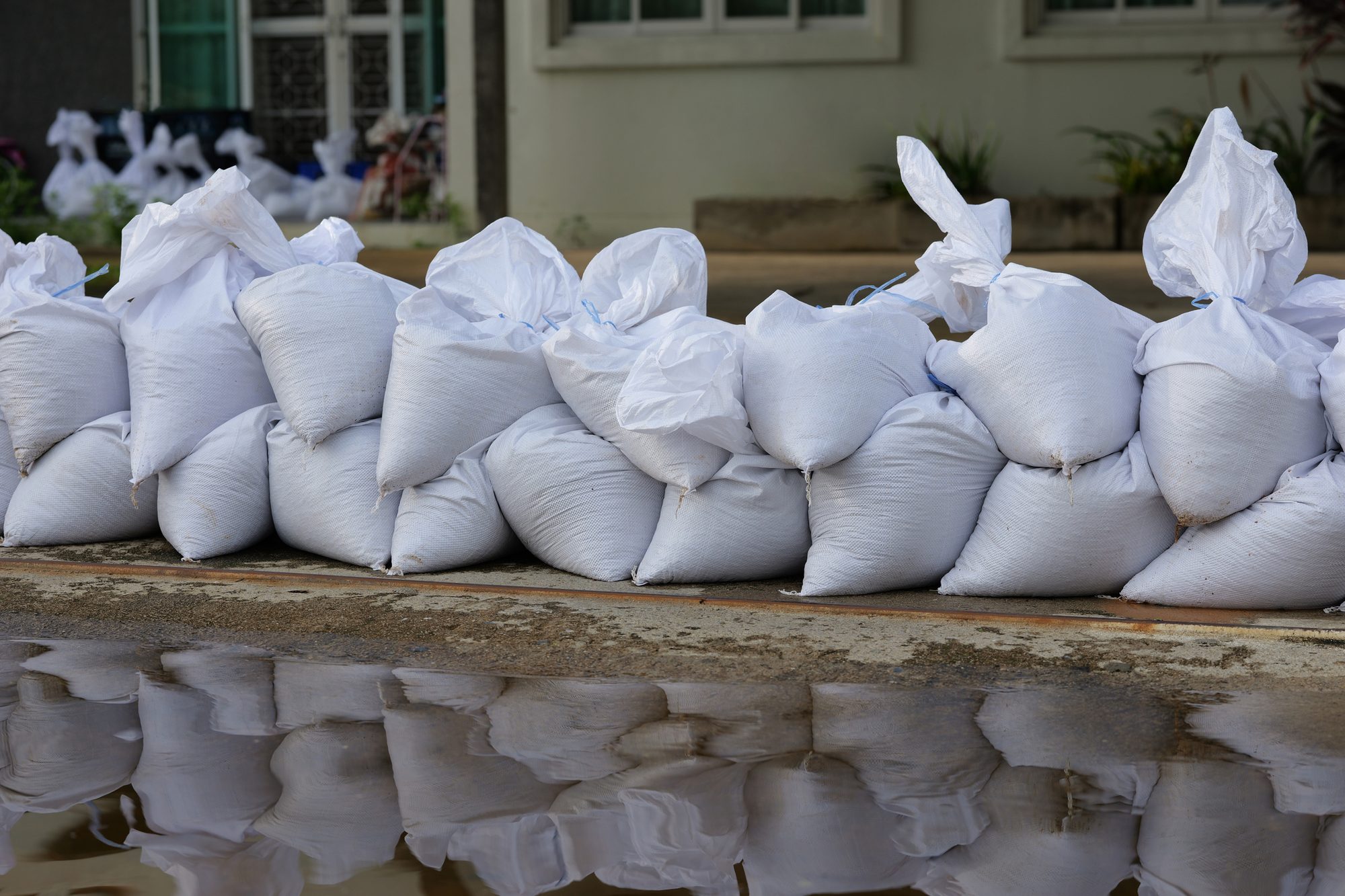 Sandbag for flood protection. A pile or wall of sandbags at the front entrance of a house to keep flooding water out of the residence, and separate wet and dry zone