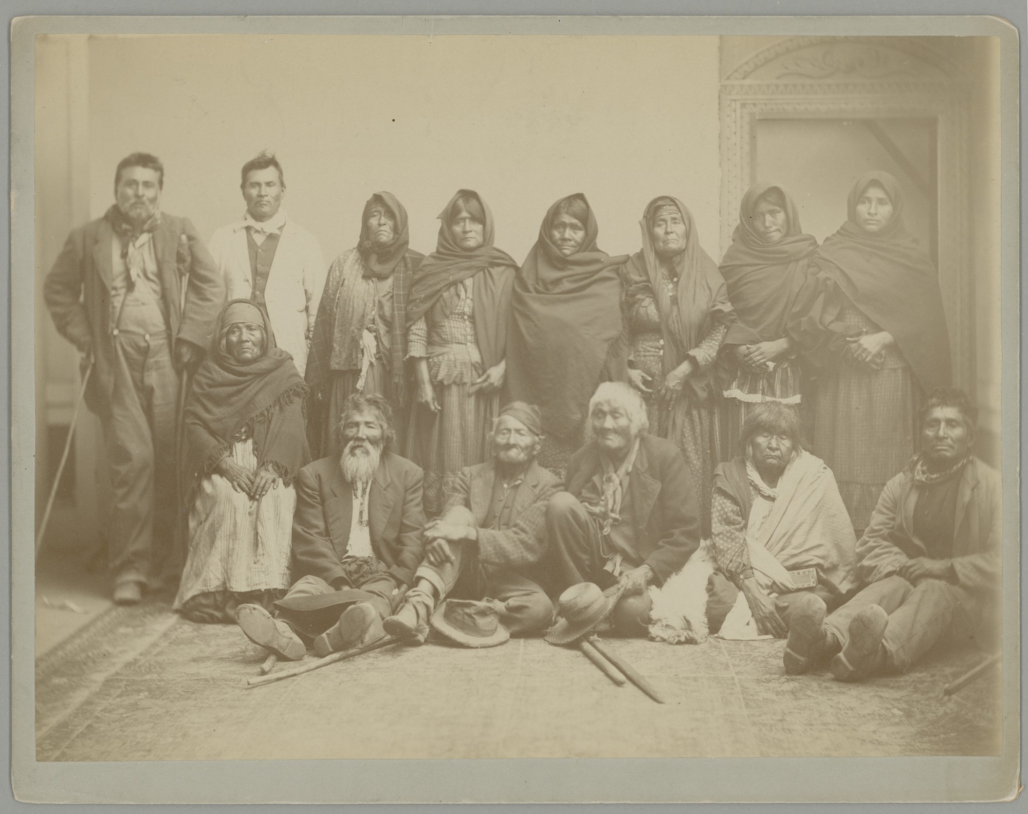 Historical group portrait of Kumeyaay men and women in mixed traditional and Western clothing.