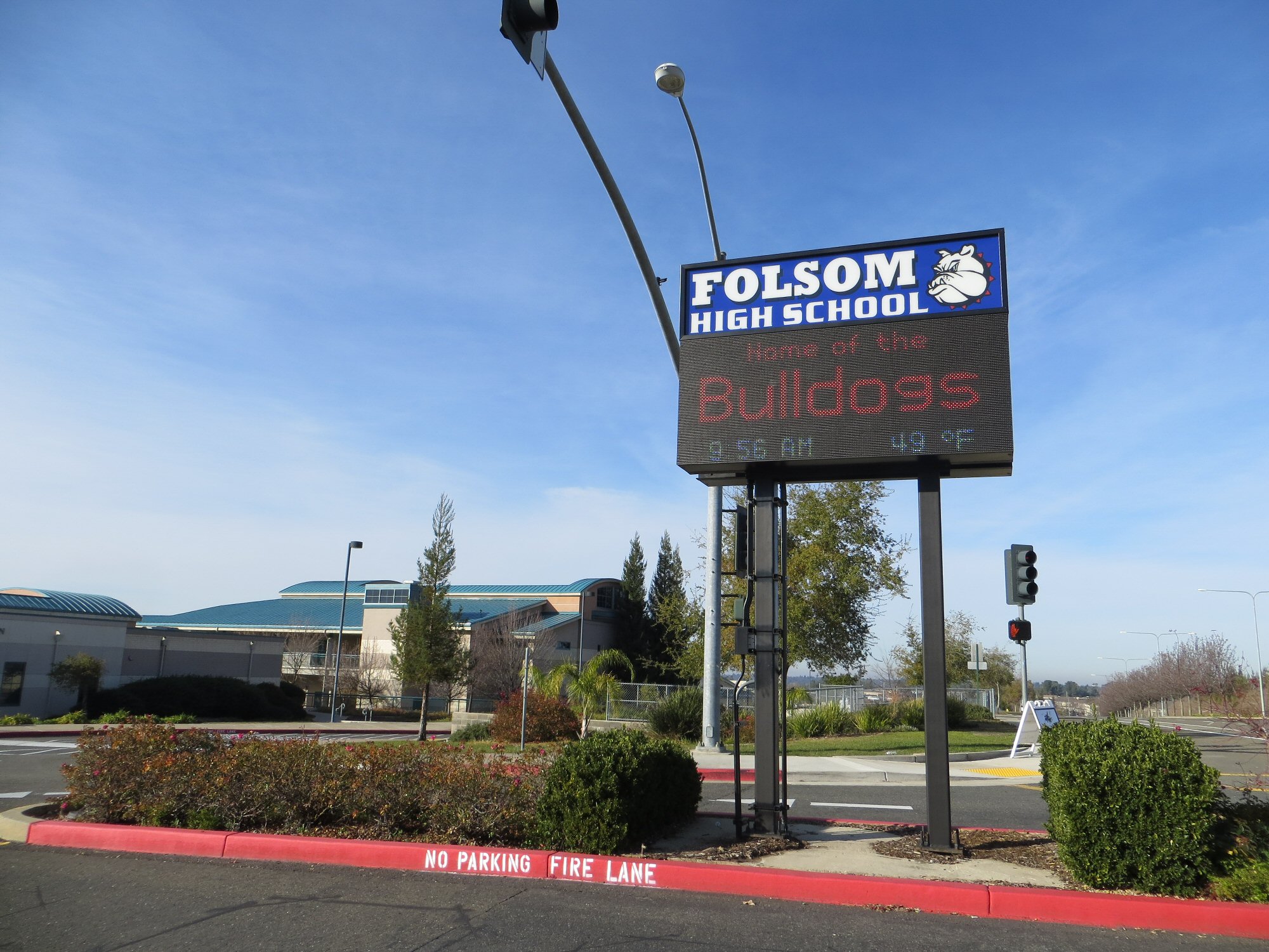 Electronic marquee sign reading Bulldogs outside a school building.