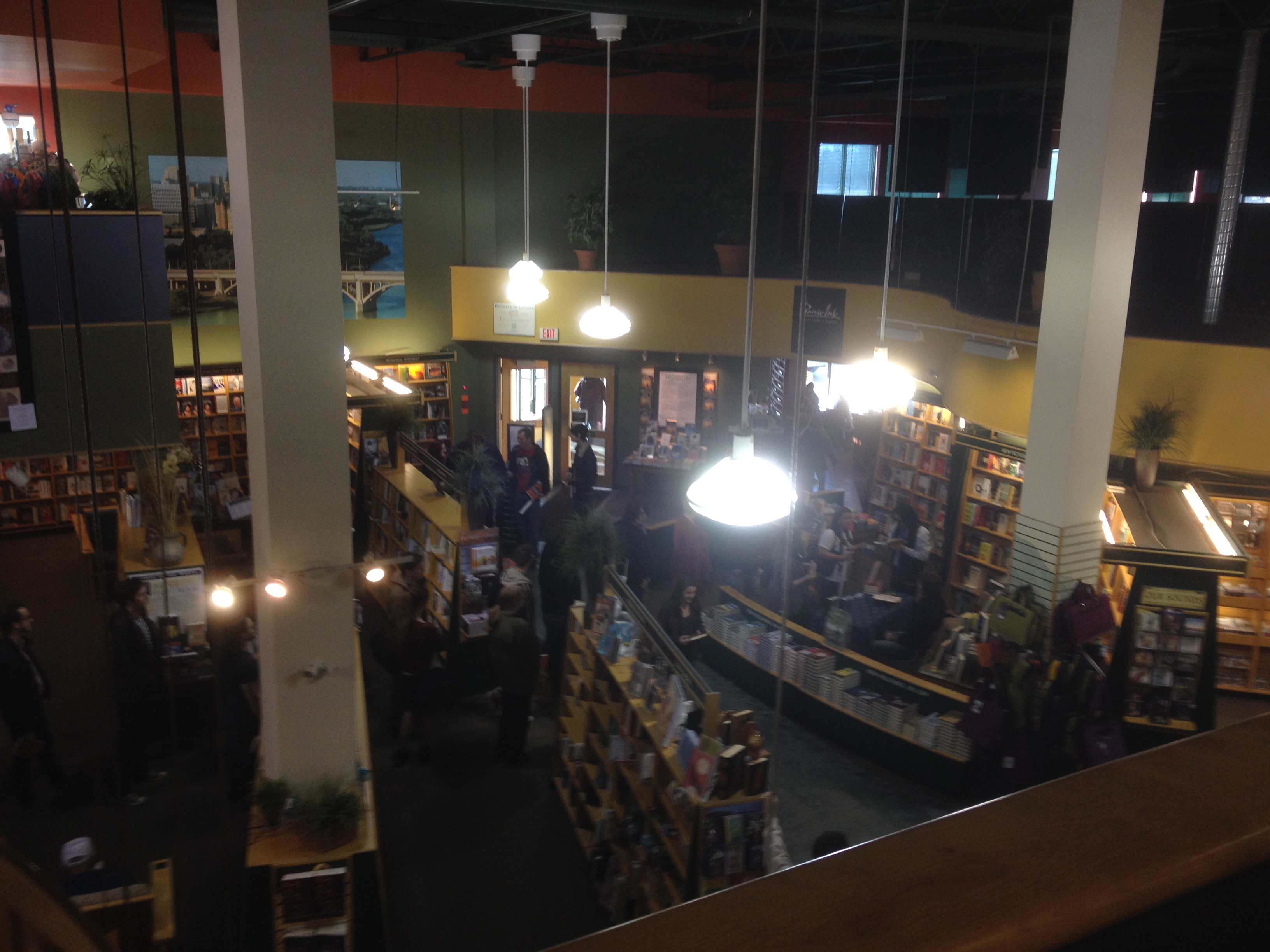 Interior of a multi-level independent bookstore with bookshelves and patrons gathered below.