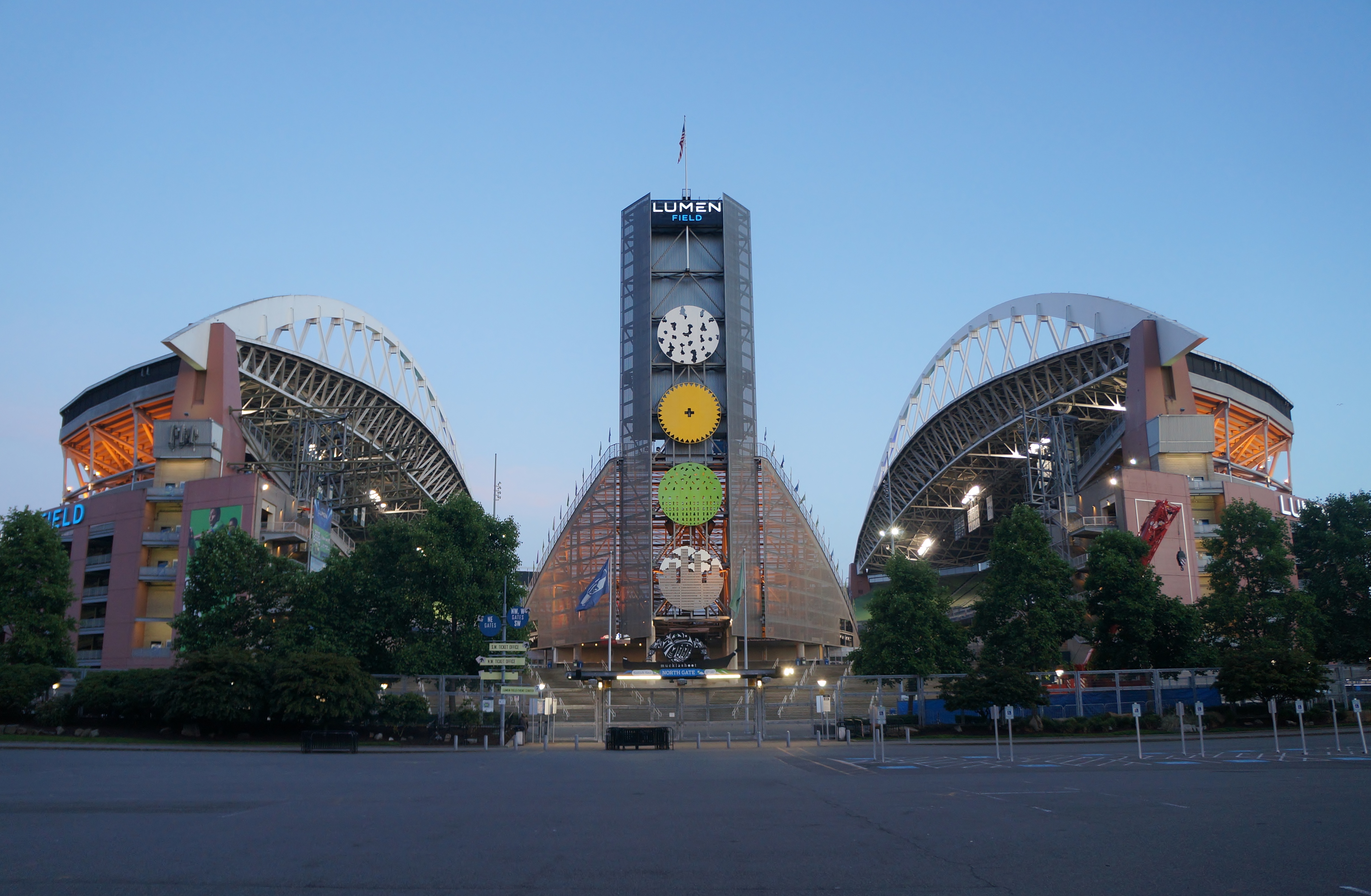 Exterior of Lumen Field stadium at dusk with arched roof structures and signage visible.