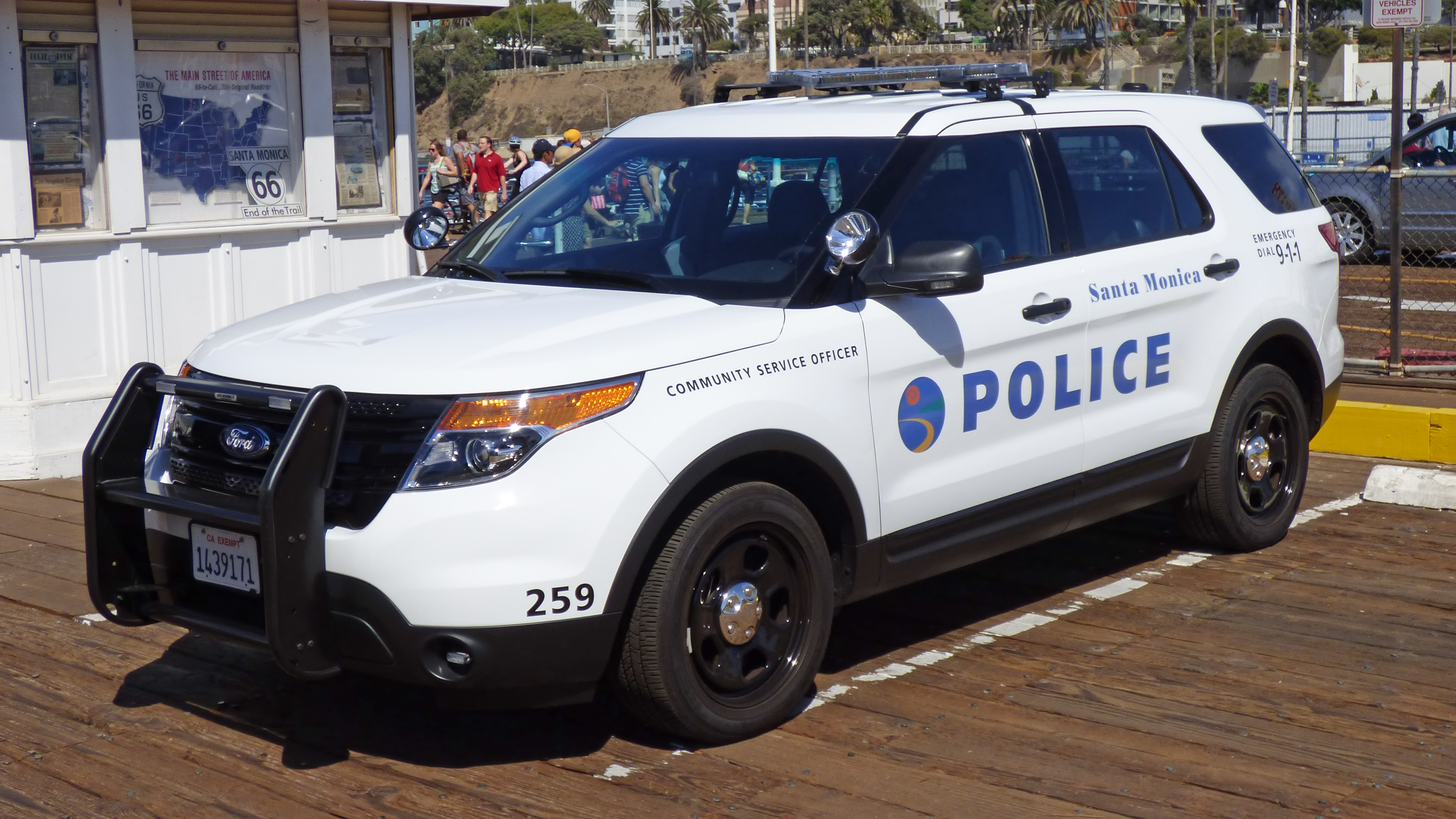 White SUV marked Santa Monica Police Community Service Officer parked on a wooden pier.