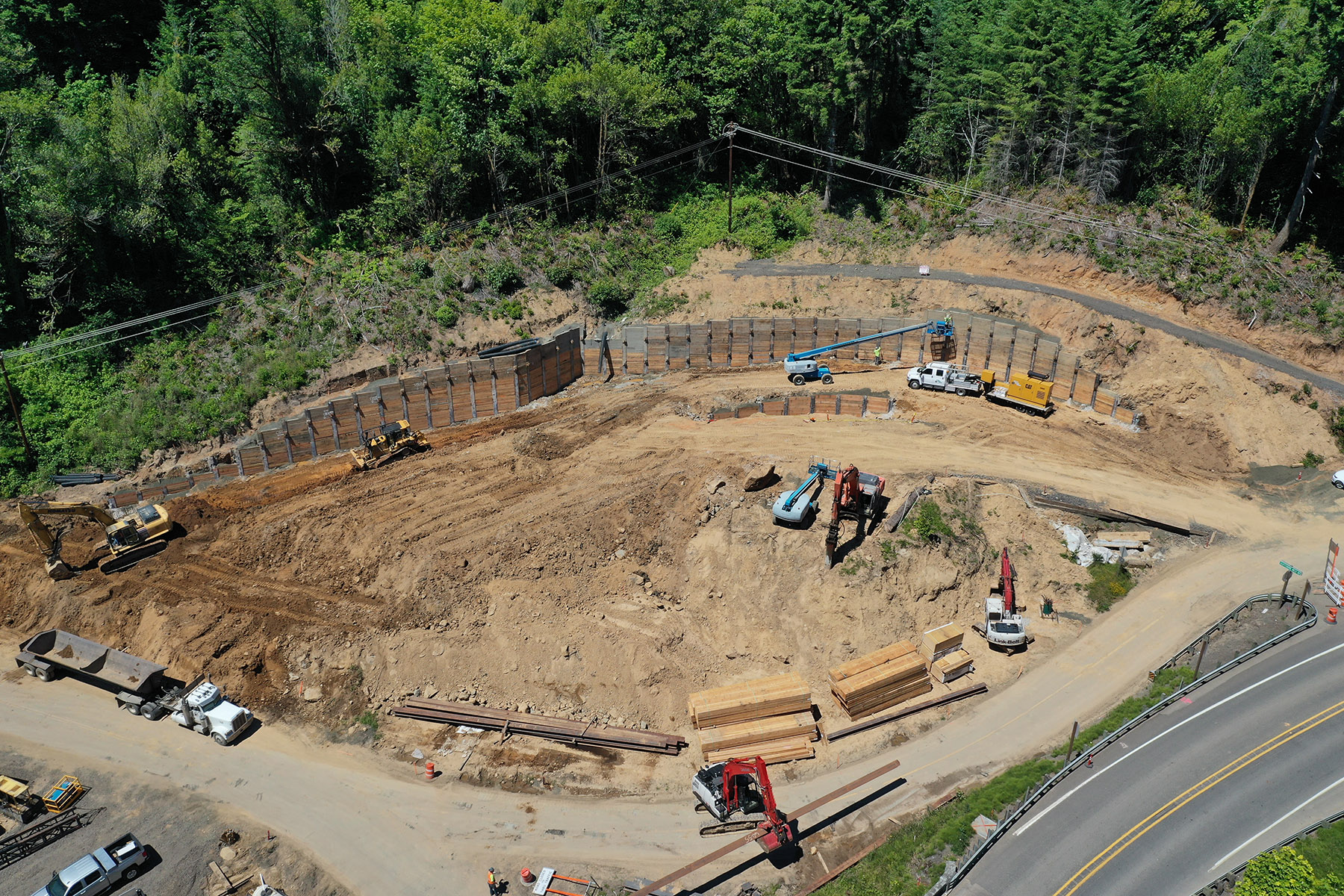 Aerial view of a large road and bridge construction site with heavy equipment and earthwork.