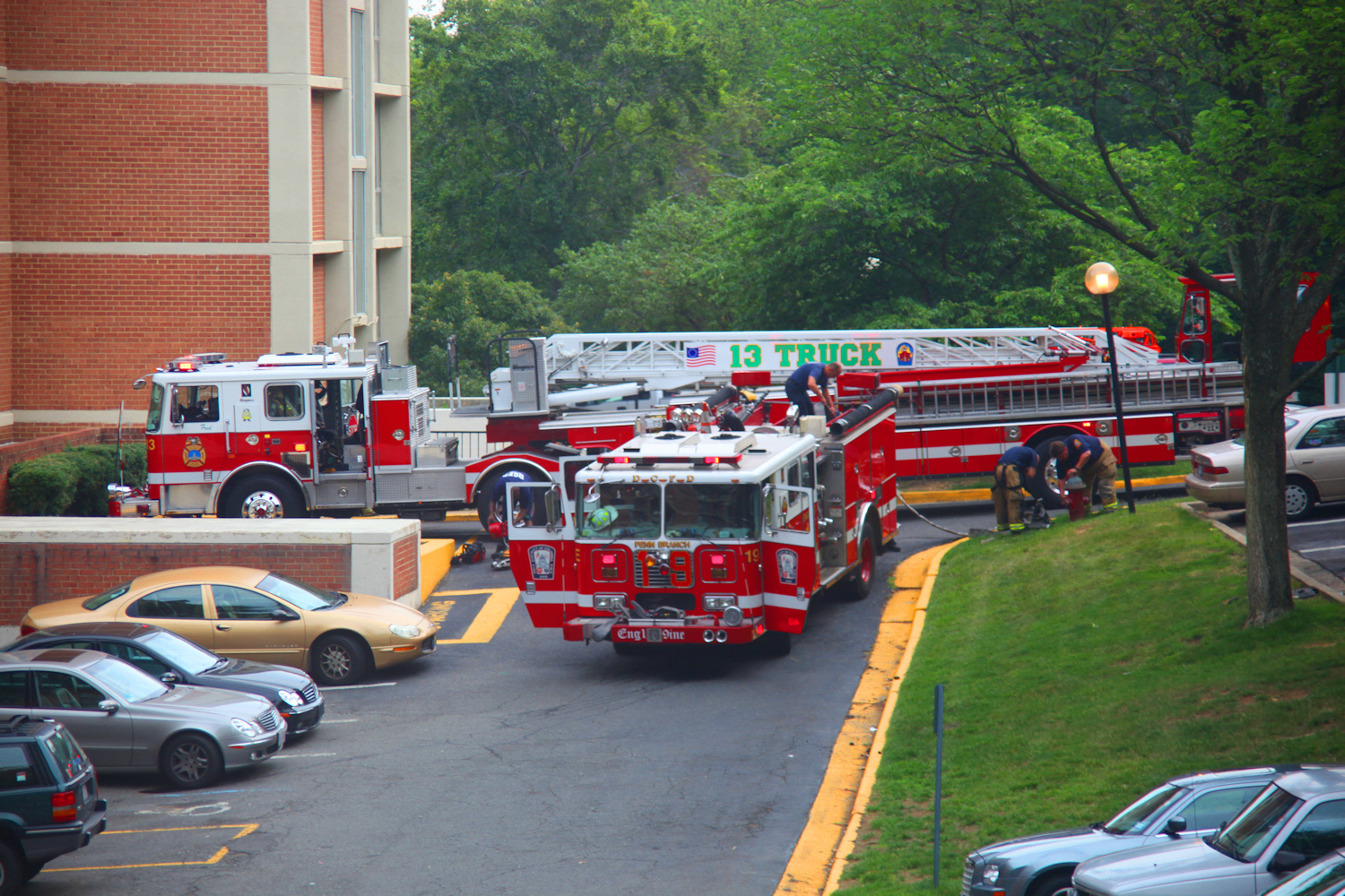 Two red fire trucks parked between buildings after responding to a call.