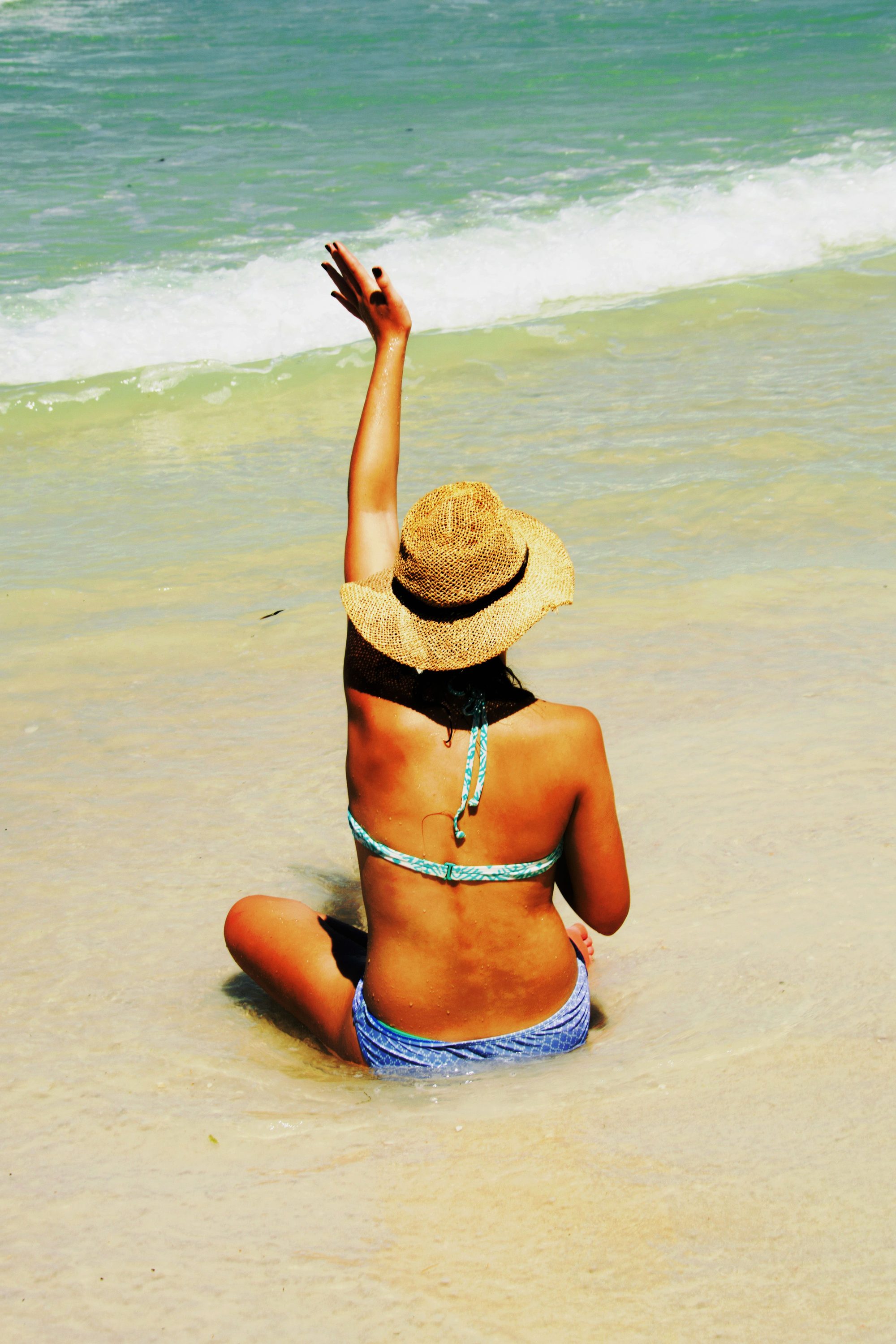 A woman in a bikini enjoys the summer sun on Sarasota beach.