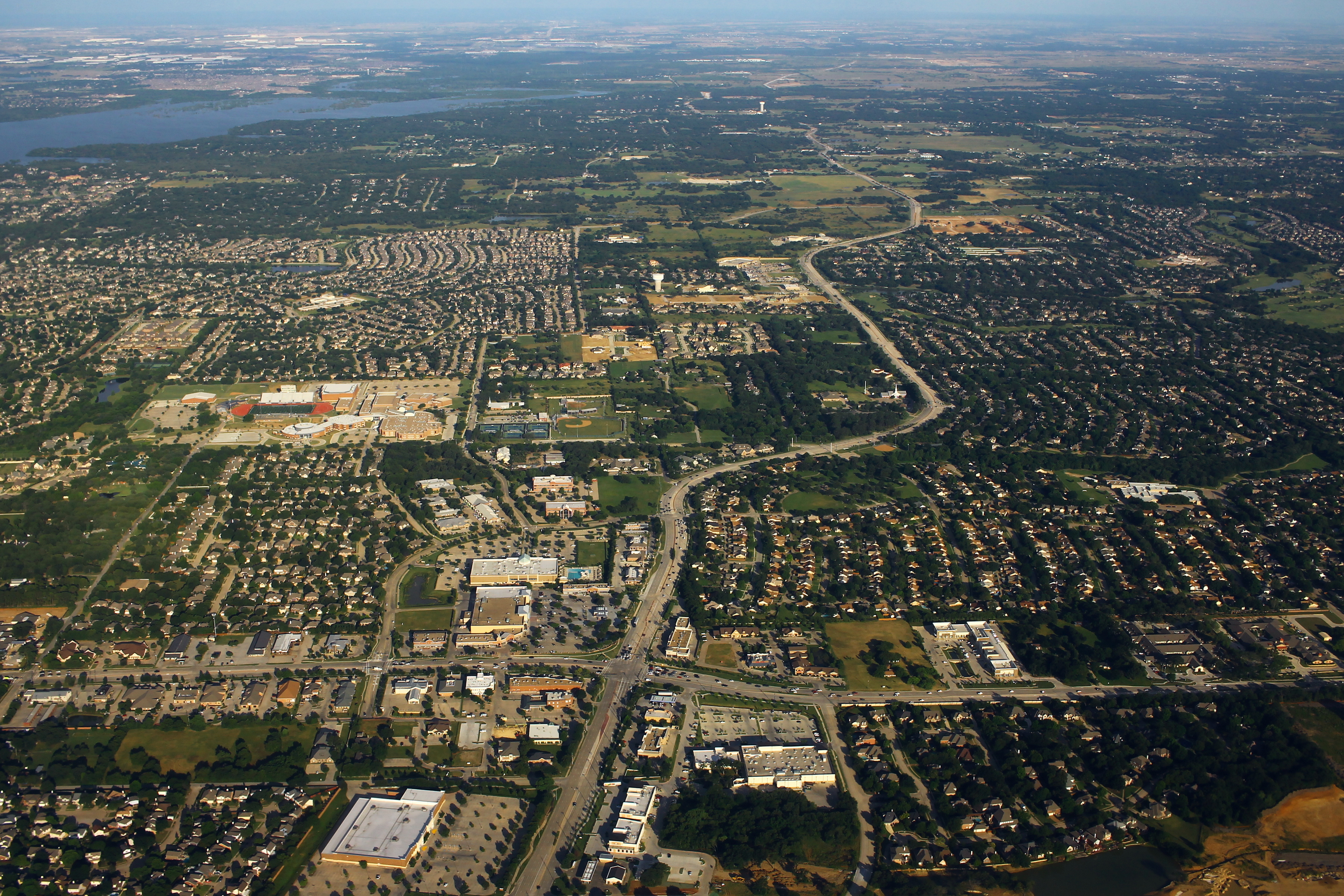Aerial view of suburban neighborhoods, roads, and open land in Flower Mound, Texas.