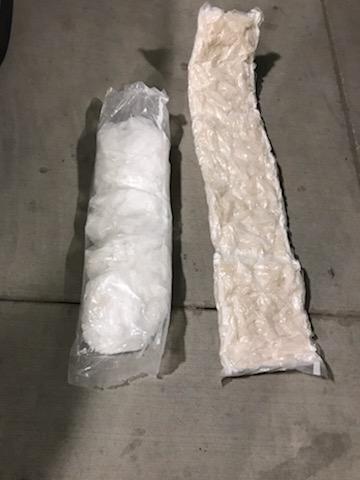 Two plastic-wrapped packages of white crystalline and off-white substances on a surface.