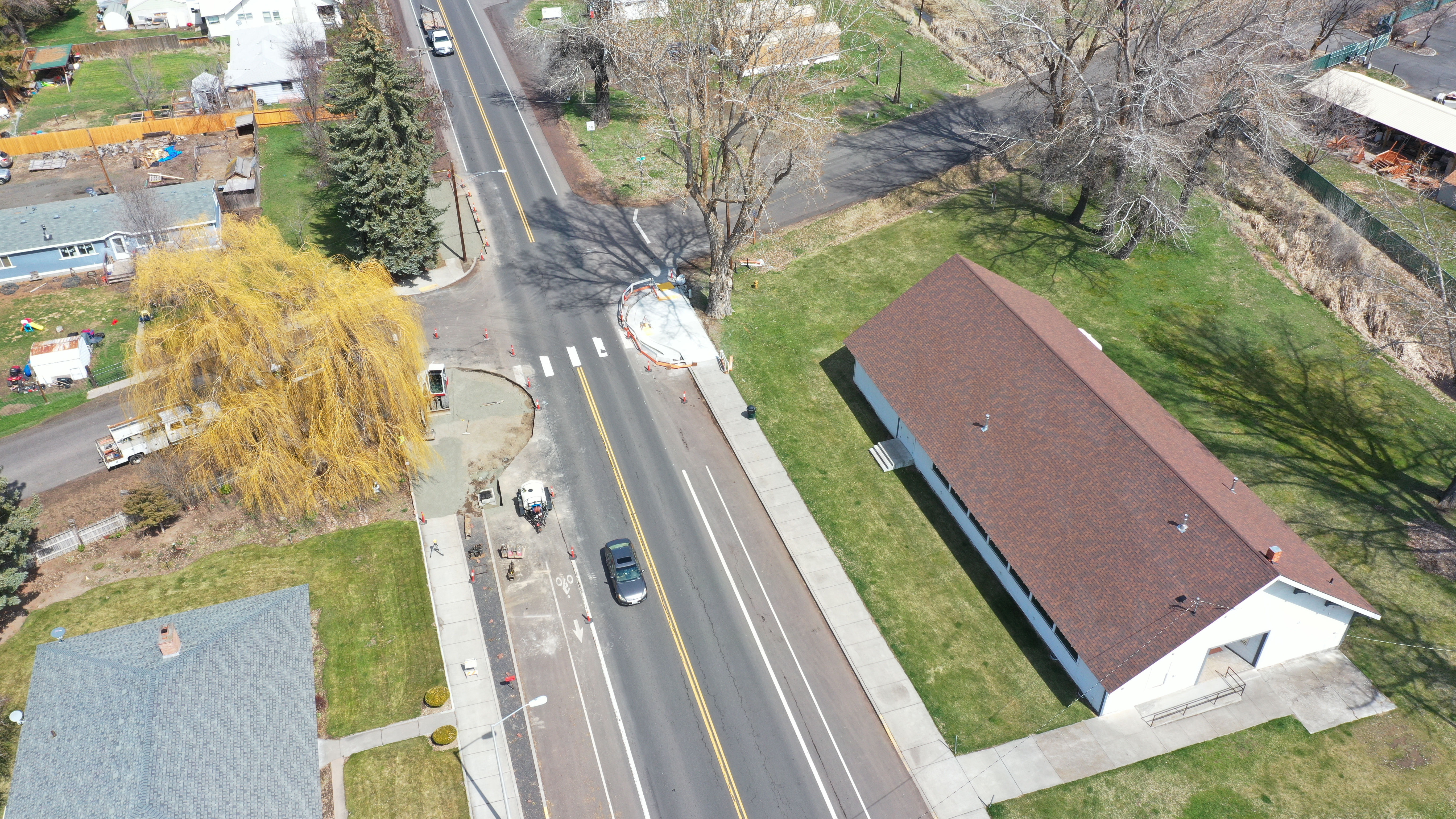 Aerial view of a road intersection with new curb ramps, crosswalk markings, and sidewalks.